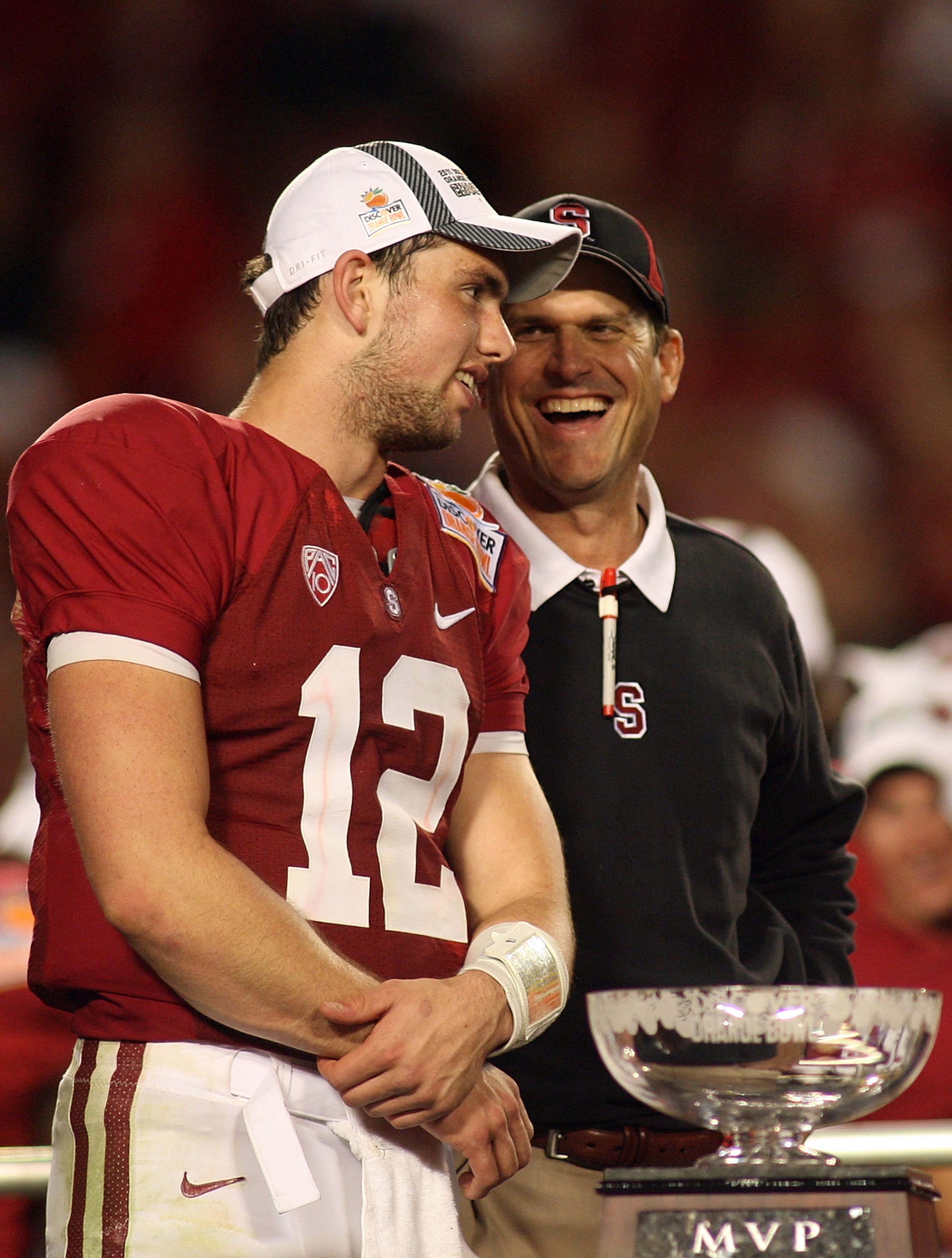 MIAMI, FL - JANUARY 03:  (L-R) Quarterback Andrew Luck and head coach Jim Harbaugh of the Stanford Cardinal celebrate with the trophy on stage after Stanford won 40-12 against the Virginai Tech Hokies during the 2011 Discover Orange Bowl at Sun Life Stadi