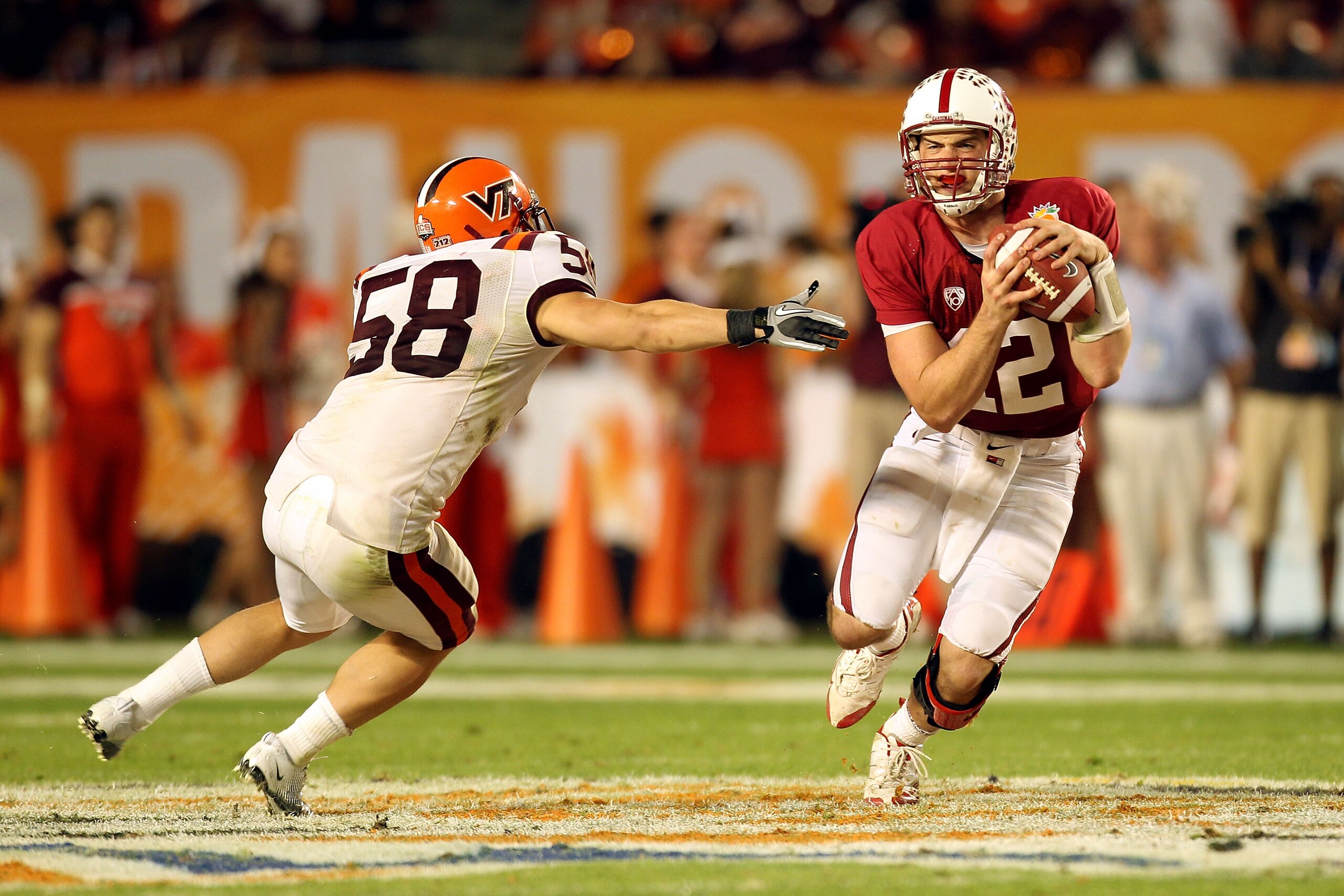 MIAMI, FL - JANUARY 03:  Andrew Luck #12 of the Stanford Cardinal ellude Jack Tyler #58 of the Virginai Tech Hokies during the 2011 Discover Orange Bowl at Sun Life Stadium on January 3, 2011 in Miami, Florida. STanford won 40-12.  (Photo by Mike Ehrmann/