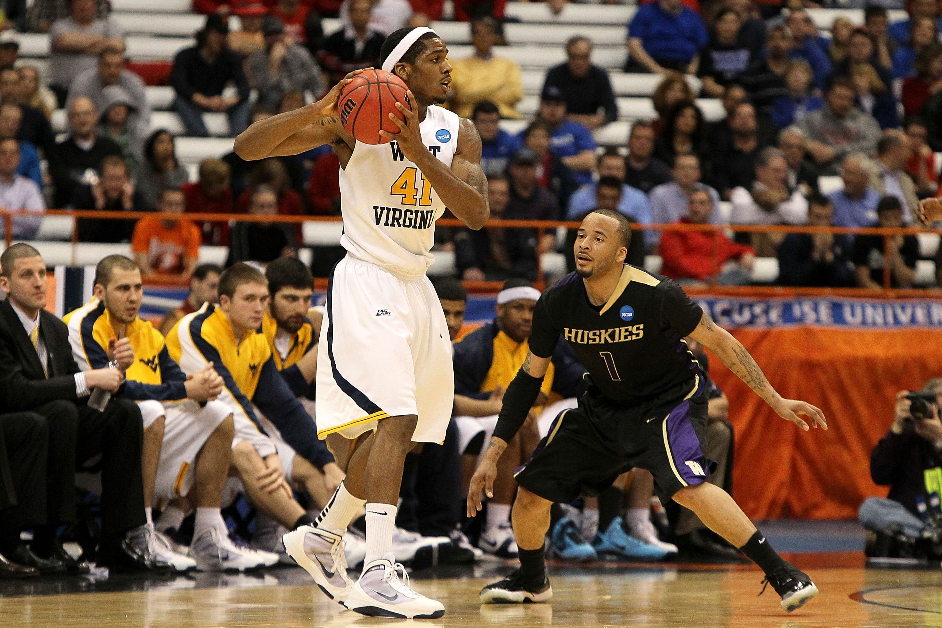 SYRACUSE, NY - MARCH 25:  John Flowers #41 of the West Virginia Mountaineers looks to pass the ball against Venoy Overton #1 of the Washington Huskies during the east regional semifinal of the 2010 NCAA men's basketball tournament at the Carrier Dome on M