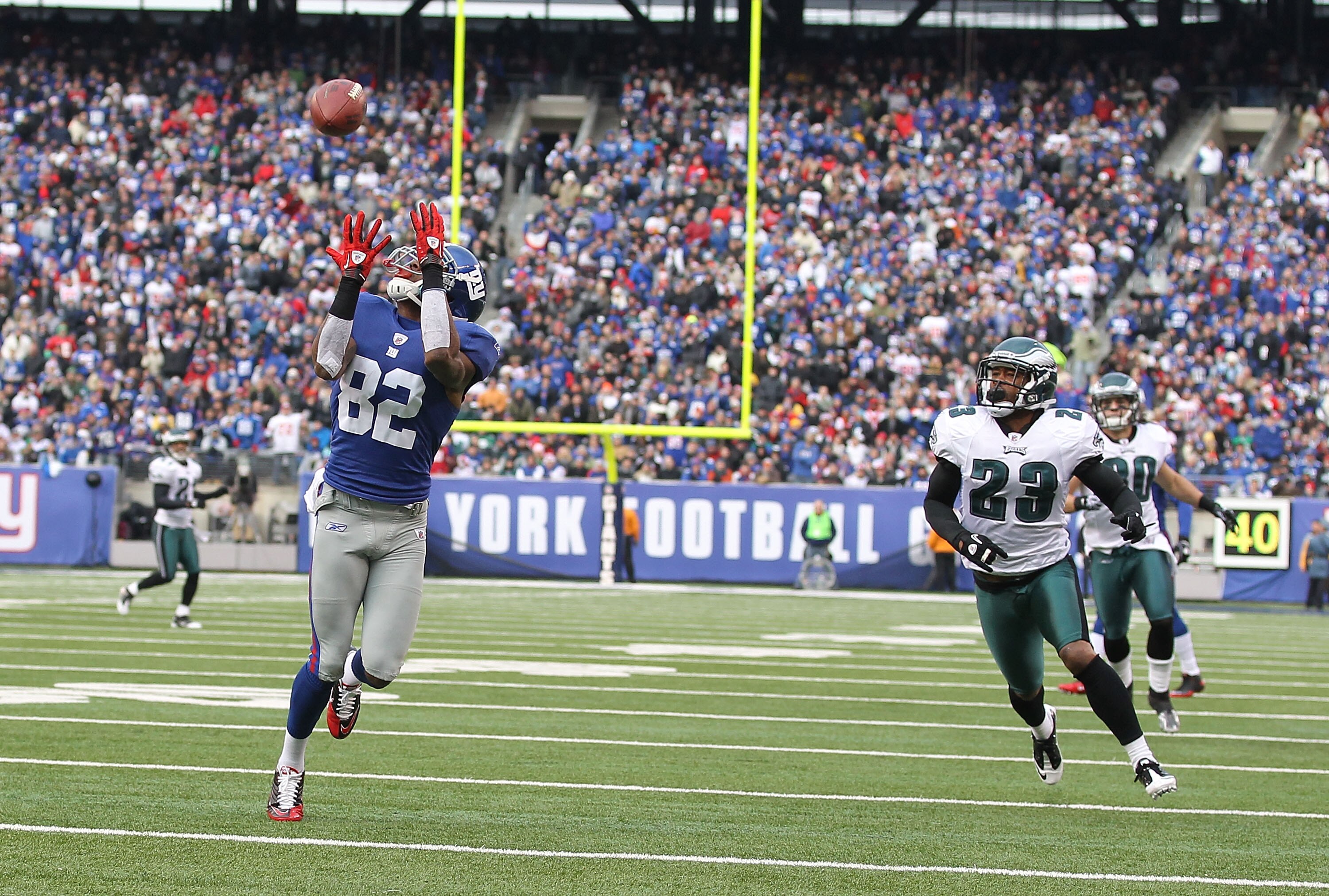 EAST RUTHERFORD, NJ - DECEMBER 19:  Mario Manningham #82 of the New York Giants scores a touchdown in the first quarter as Dimitri Patterson #23 and Colt Anderson #30 of the Philadelphia Eagles defend during their game on December 19, 2010 at The New Mead