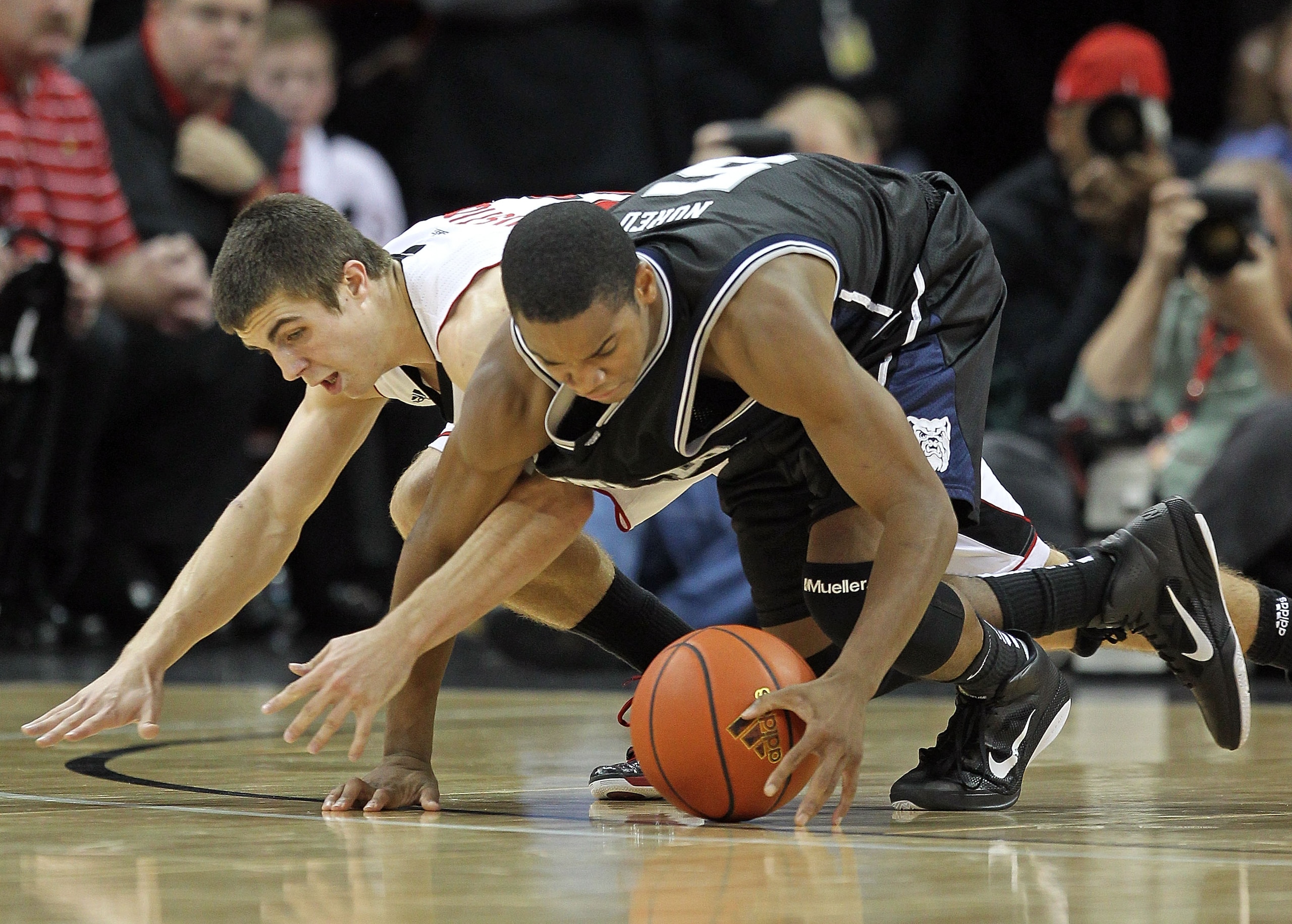 LOUISVILLE, KY - NOVEMBER 16: Ronald Nored #5 of the Butler Bulldogs and Elisha Justice #22 of the Louisville Cardinals battle for a loose ball during the game at the KFC Yum! Center on November 16, 2010 in Louisville, Kentucky. (Photo by Andy Lyons/Ge LOUISVILLE, KY - NOVEMBER 16: Ronald Nored #5 of the Butler Bulldogs and Elisha Justice #22 of the Louisville Cardinals battle for a loose ball during the game at the KFC Yum! Center on November 16, 2010 in Louisville, Kentucky. (Photo by Andy Lyons/Ge