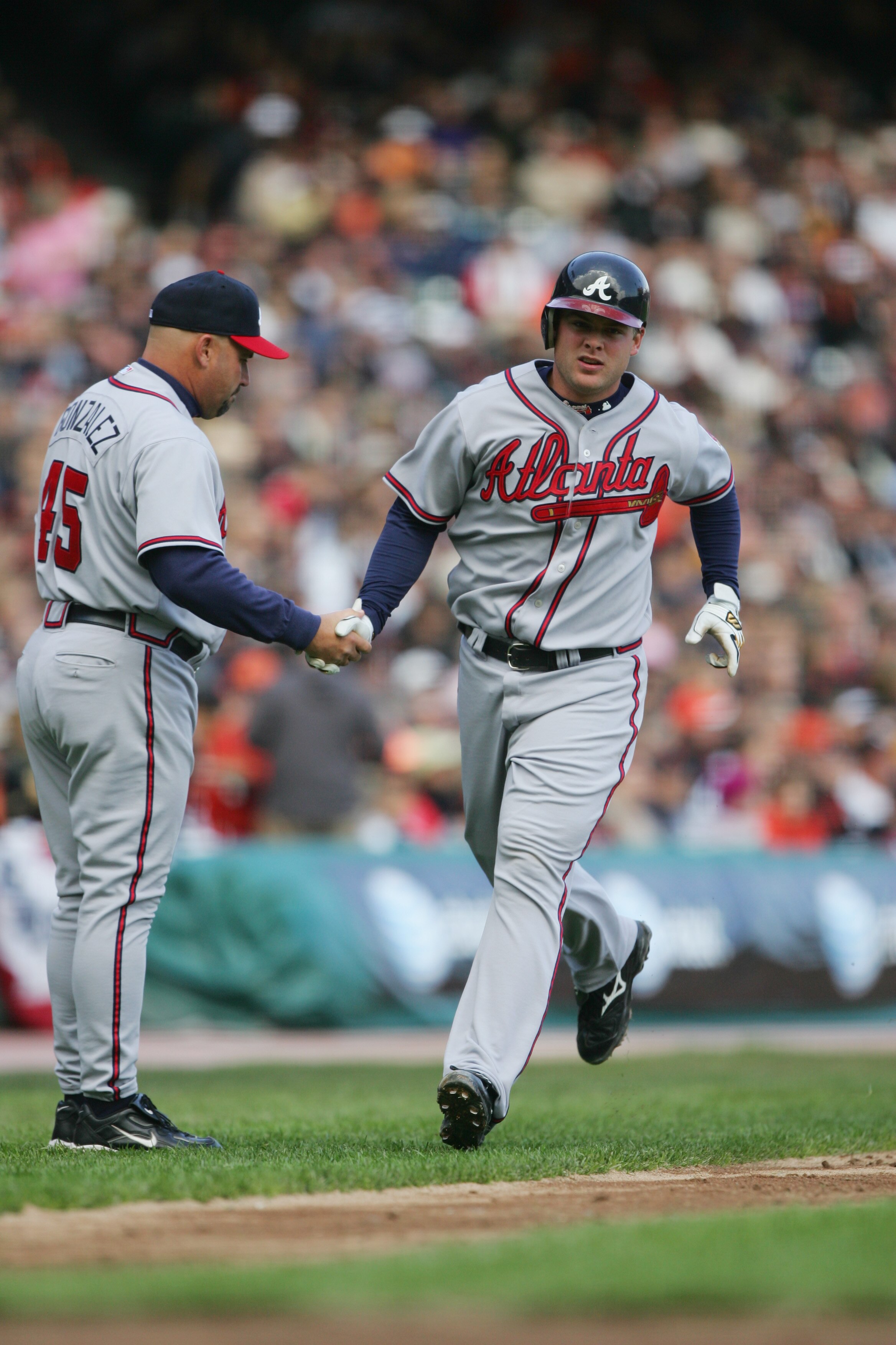 SAN FRANCISCO - APRIL 6:  Brian McCann #16 of the Atlanta Braves receives congratulations from third base coach Fredi Gonzalez after hitting a home run against the San Francisco Giants during the home opener at AT&T Park on April 6, 2006 in San Francisco,