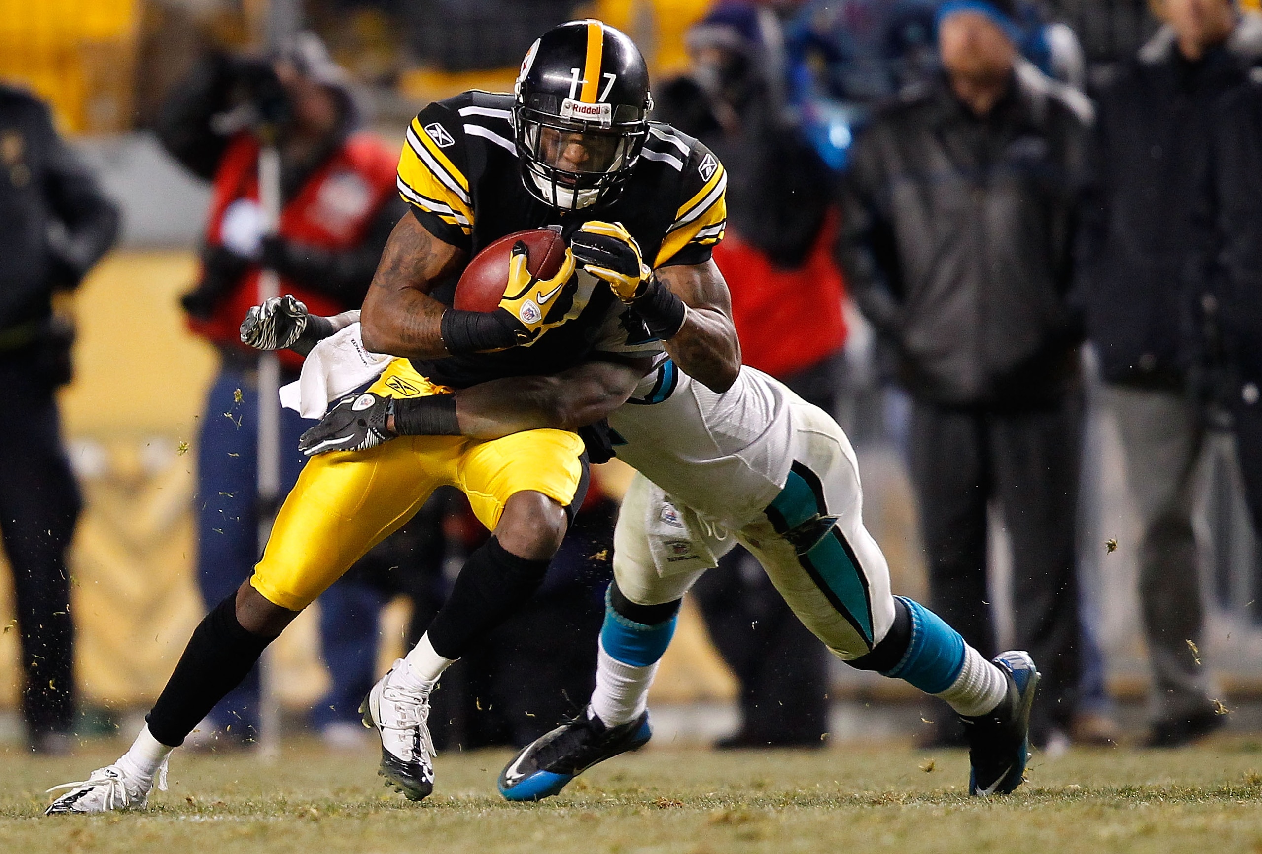 PITTSBURGH - DECEMBER 23:  Mike Wallace #17 of the Pittsburgh Steelers attempts to break a tackle after catching a pass against the Carolina Panthers during the game on December 23, 2010 at Heinz Field in Pittsburgh, Pennsylvania.  (Photo by Jared Wickerh