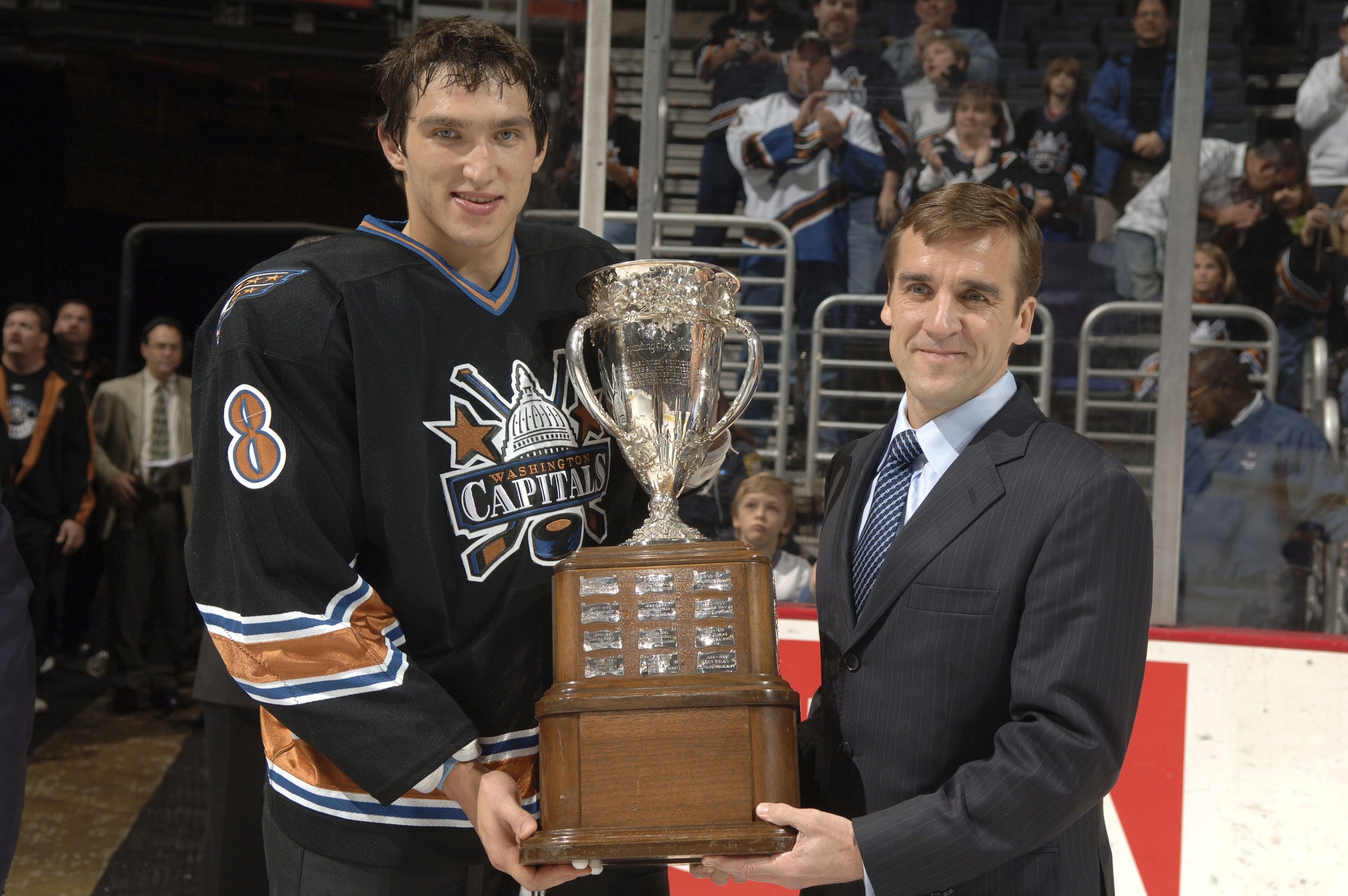 WASHINGTON - OCTOBER 14: Washington Capitals' Alex Ovechkin #8 receives the Calder Trophy from VP and General Manager of the Washington Capitals, George McPhee, before a hockey game against the Atlanta Thrashers at the Verizon Center October 14, 2006 in WASHINGTON - OCTOBER 14: Washington Capitals' Alex Ovechkin #8 receives the Calder Trophy from VP and General Manager of the Washington Capitals, George McPhee, before a hockey game against the Atlanta Thrashers at the Verizon Center October 14, 2006 in