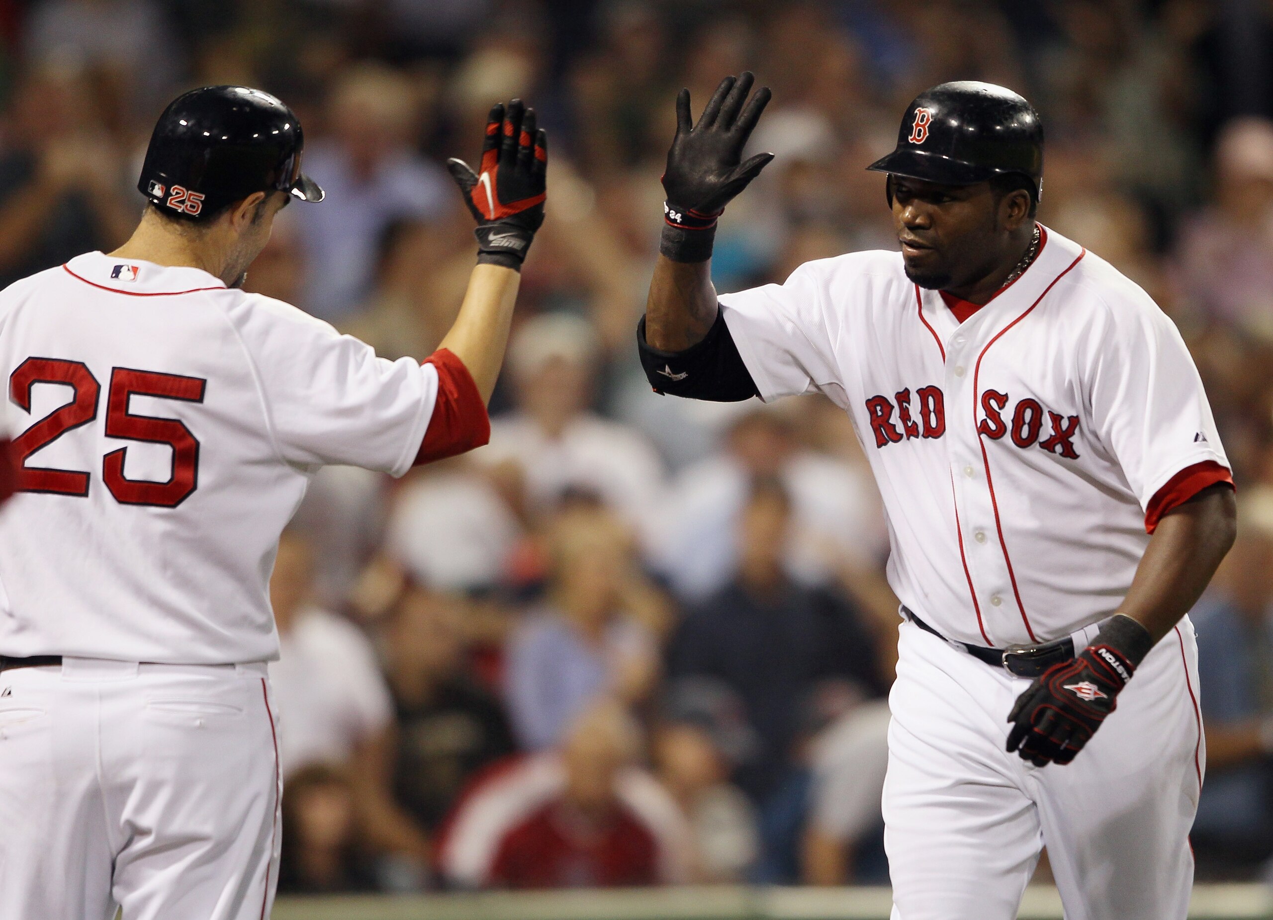 BOSTON - SEPTEMBER 22:  David Ortiz #34 of the Boston Red Sox is congratulated by teammate Miike Lowell #25 after Ortiz hit a three run homer in the fourth inning against the Baltimore Orioles on September 22, 2010 at Fenway Park in Boston, Massachusetts.