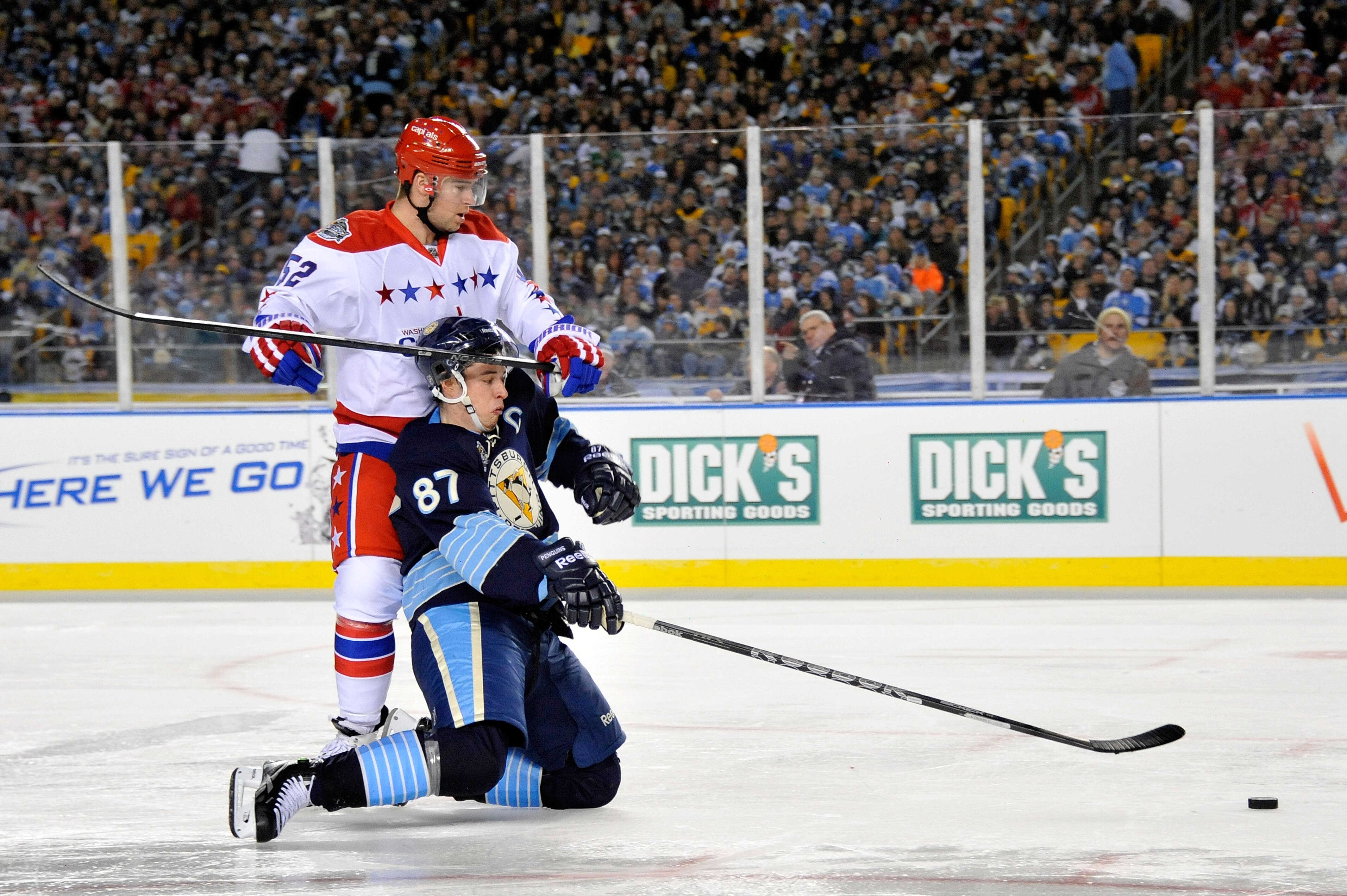 PITTSBURGH, PA - JANUARY 01:  Sidney Crosby #87 of the Pittsburgh Penguins battles for the puck against Mike Green #52 of the Washington Capitals during the 2011 NHL Bridgestone Winter Classic at Heinz Field on January 1, 2011 in Pittsburgh, Pennsylvania.