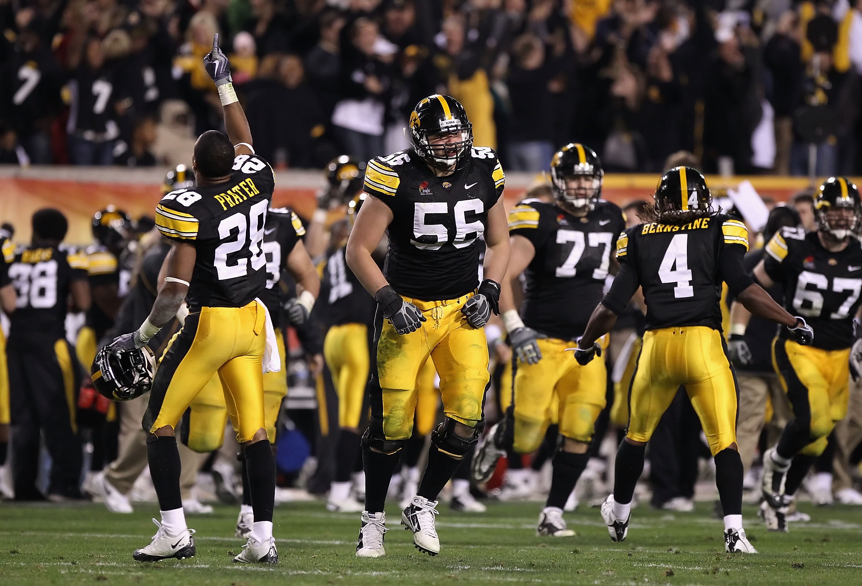 TEMPE, AZ - DECEMBER 28:  (L-R) Shaun Prater #28, Markus Zusevics #56 and Jordan Bernstine #4 of the Iowa Hawkeyes celebrate after a turnover to the Missouri Tigers was overturned late in the fourth quarter of the Insight Bowl at Sun Devil Stadium on Dece
