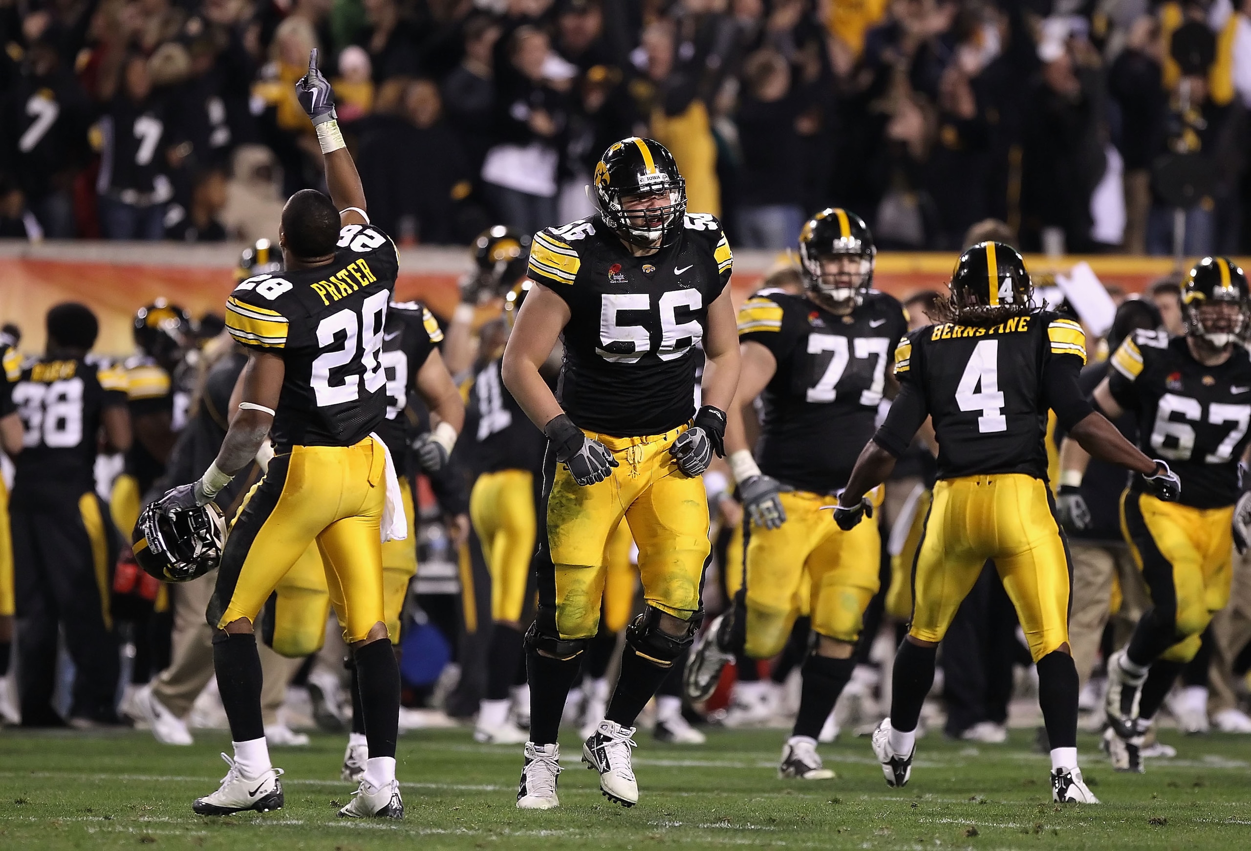 TEMPE, AZ - DECEMBER 28:  (L-R) Shaun Prater #28, Markus Zusevics #56 and Jordan Bernstine #4 of the Iowa Hawkeyes celebrate after a turnover to the Missouri Tigers was overturned late in the fourth quarter of the Insight Bowl at Sun Devil Stadium on Dece