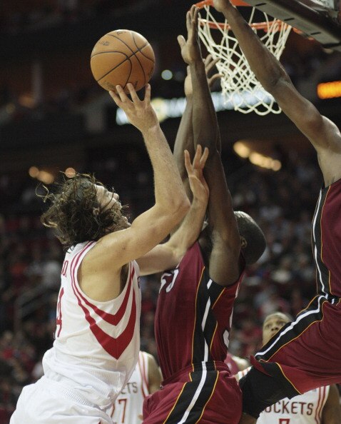 HOUSTON - DECEMBER 29: Luis Scola #4 of the Houston Rockets is foulded by Joel Anthony #50 of the Miami Heat as he drives to the basket in the second half at Toyota Center on December 29, 2010 in Houston, Texas. NOTE TO USER: User expressly acknowledges a