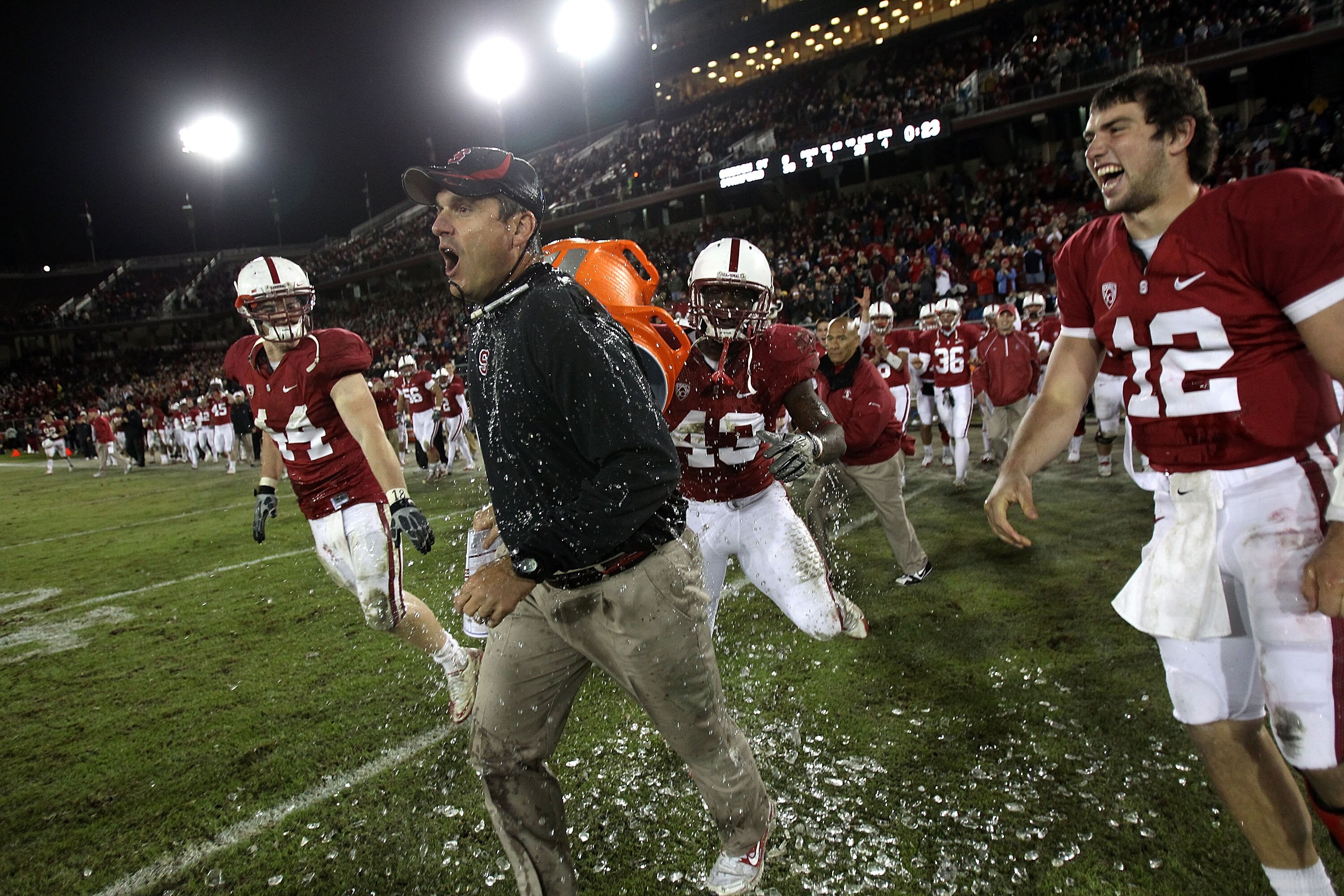 PALO ALTO, CA - NOVEMBER 27:  Head coach Jim Harbaugh of the Stanford Cardinal is covered with water from a Gatorade cooler by Andrew Luck #12 and Chike Amajoyi #43 after the Cardinal beat the Oregon State Beavers at Stanford Stadium on November 27, 2010 