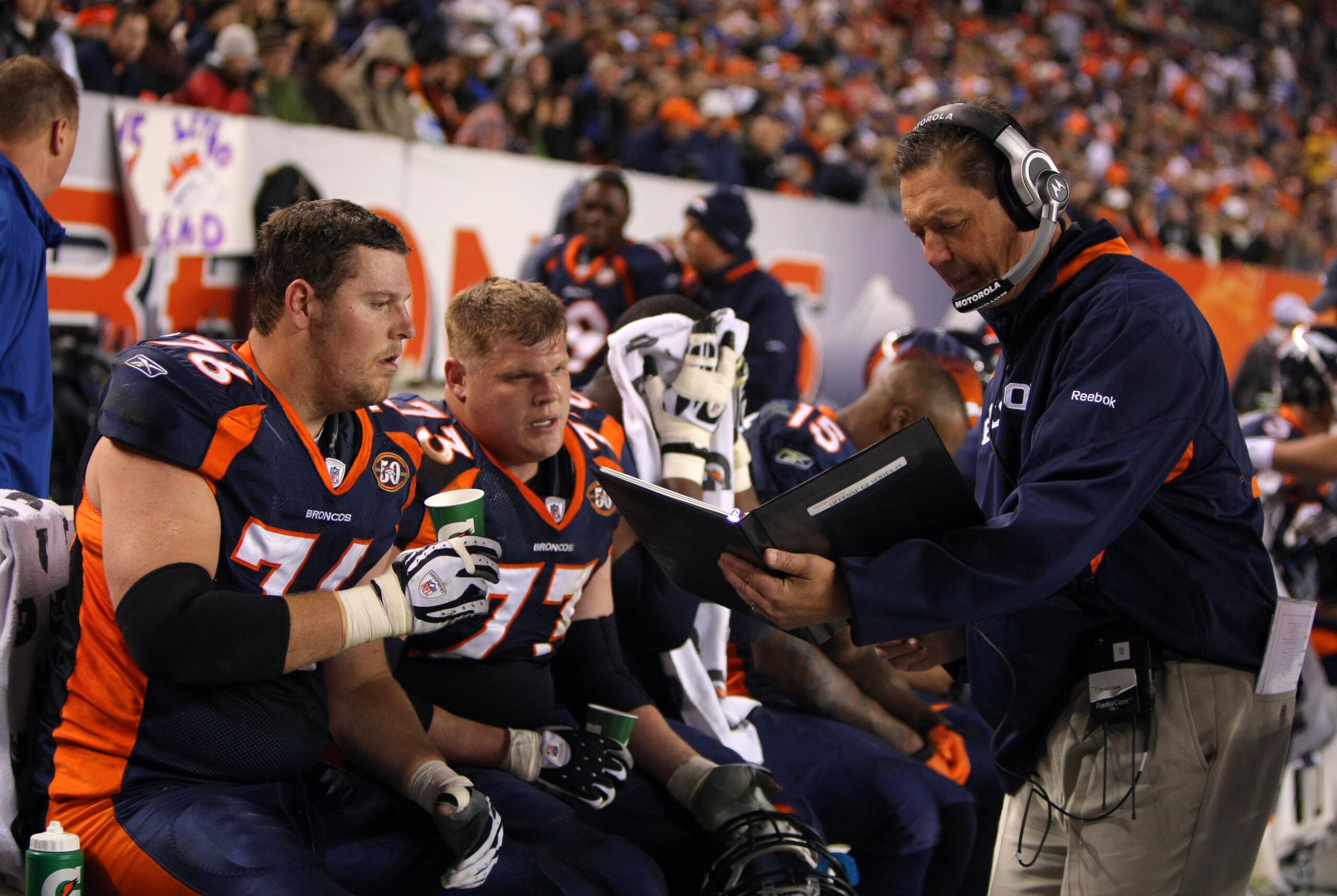 DENVER - NOVEMBER 26: Offensive line coach Rick Dennison and Chris Kuper #73 and Tyler Polumbus #76 of the Denver Broncos look over photos in the bench area during their NFL game against the New York Giants at Invesco Field at Mile High on November 26, 2 DENVER - NOVEMBER 26: Offensive line coach Rick Dennison and Chris Kuper #73 and Tyler Polumbus #76 of the Denver Broncos look over photos in the bench area during their NFL game against the New York Giants at Invesco Field at Mile High on November 26, 2