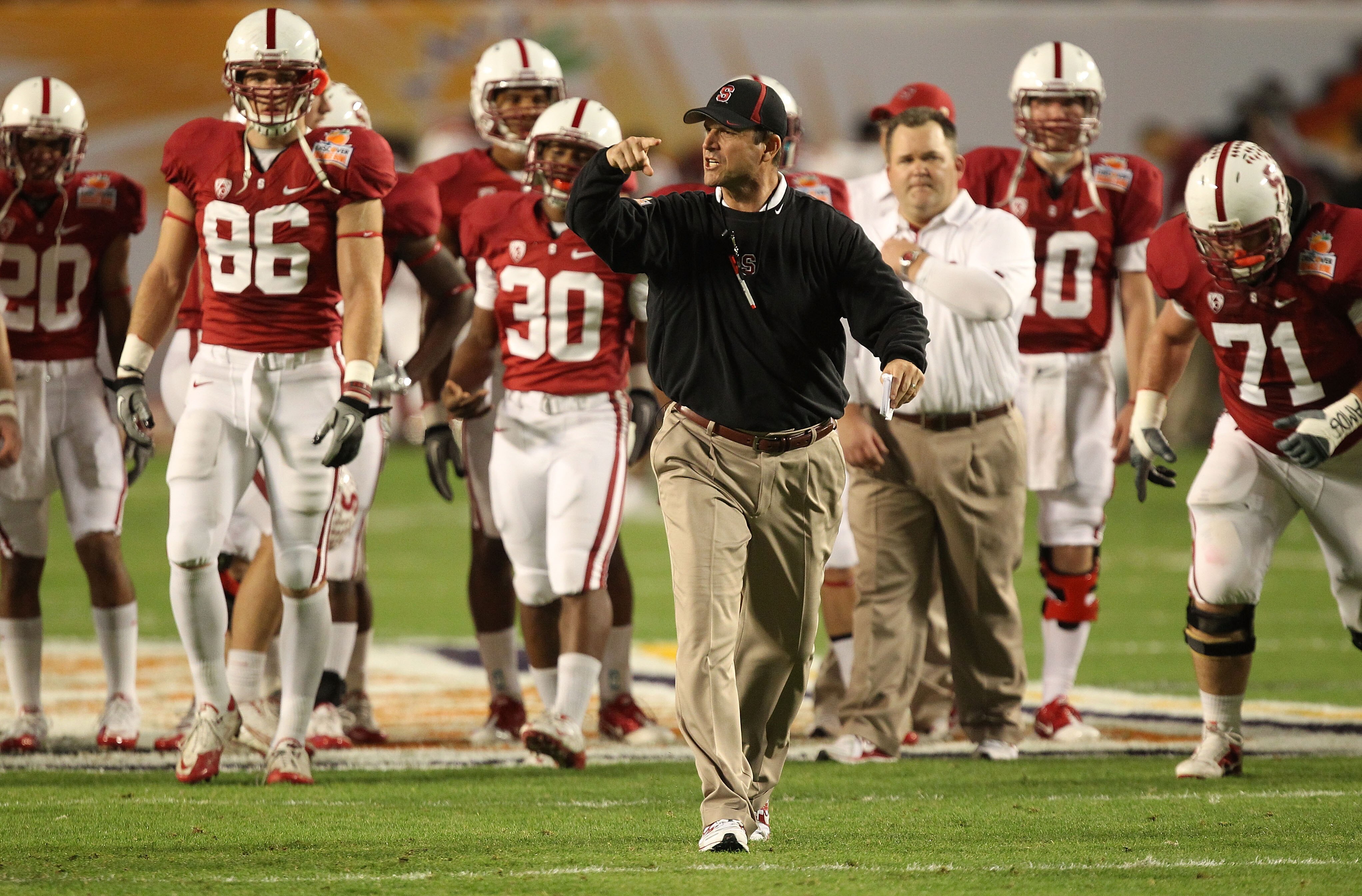 MIAMI, FL - JANUARY 03:  Head coach Jim Harbaugh of the Stanford Cardinal instructs his players during warm ups against the Virginai Tech Hokies during the 2011 Discover Orange Bowl at Sun Life Stadium on January 3, 2011 in Miami, Florida.  (Photo by Stre