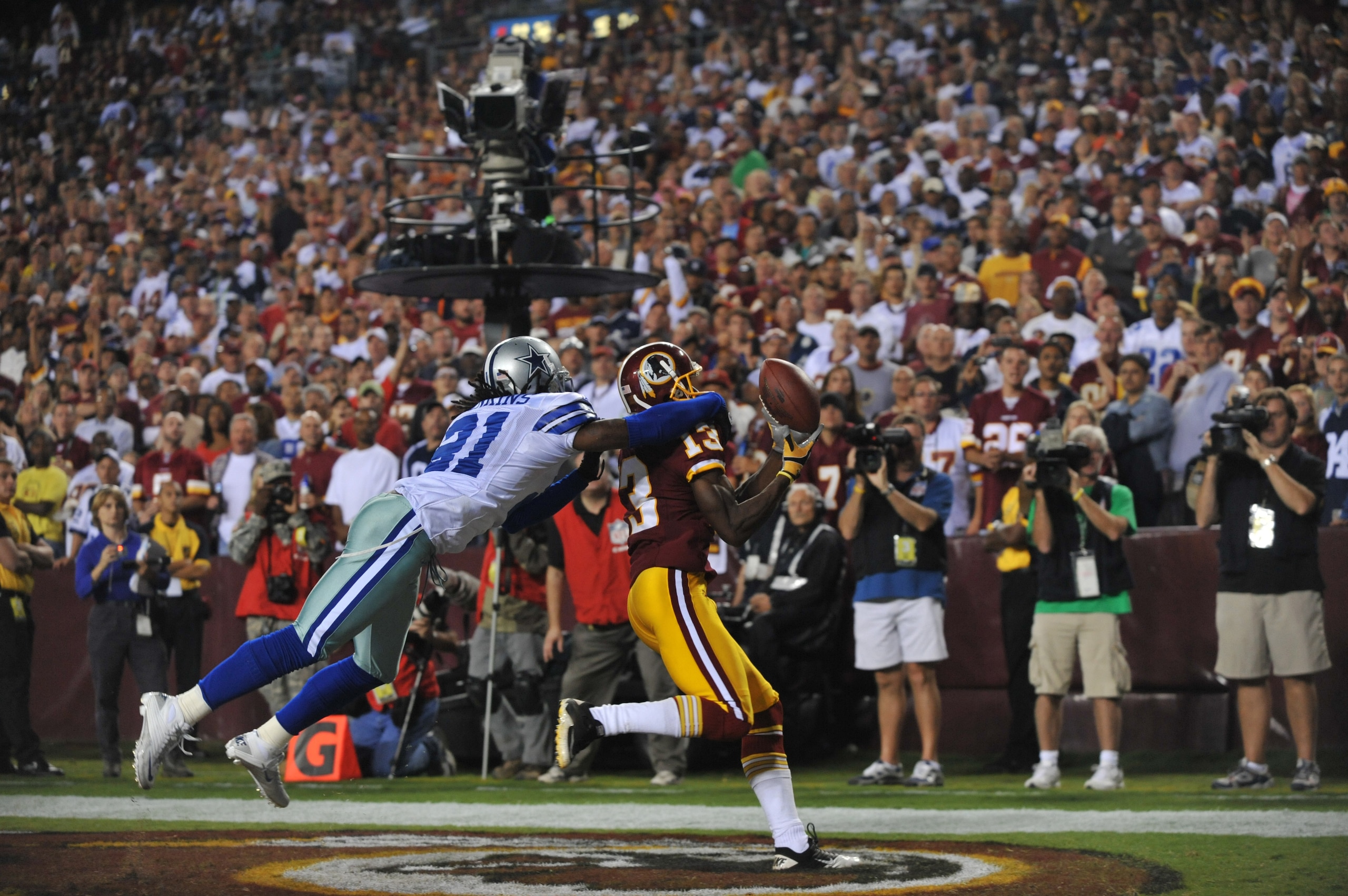 LANDOVER - SEPTEMBER 12:  Mike Jenkins #21 of the Dallas Cowboys knocks the ball loose from Anthony Armstrong #13 of the Washington Redskins during the NFL season opener at FedExField on September 12, 2010 in Landover, Maryland. The Redskins defeated the