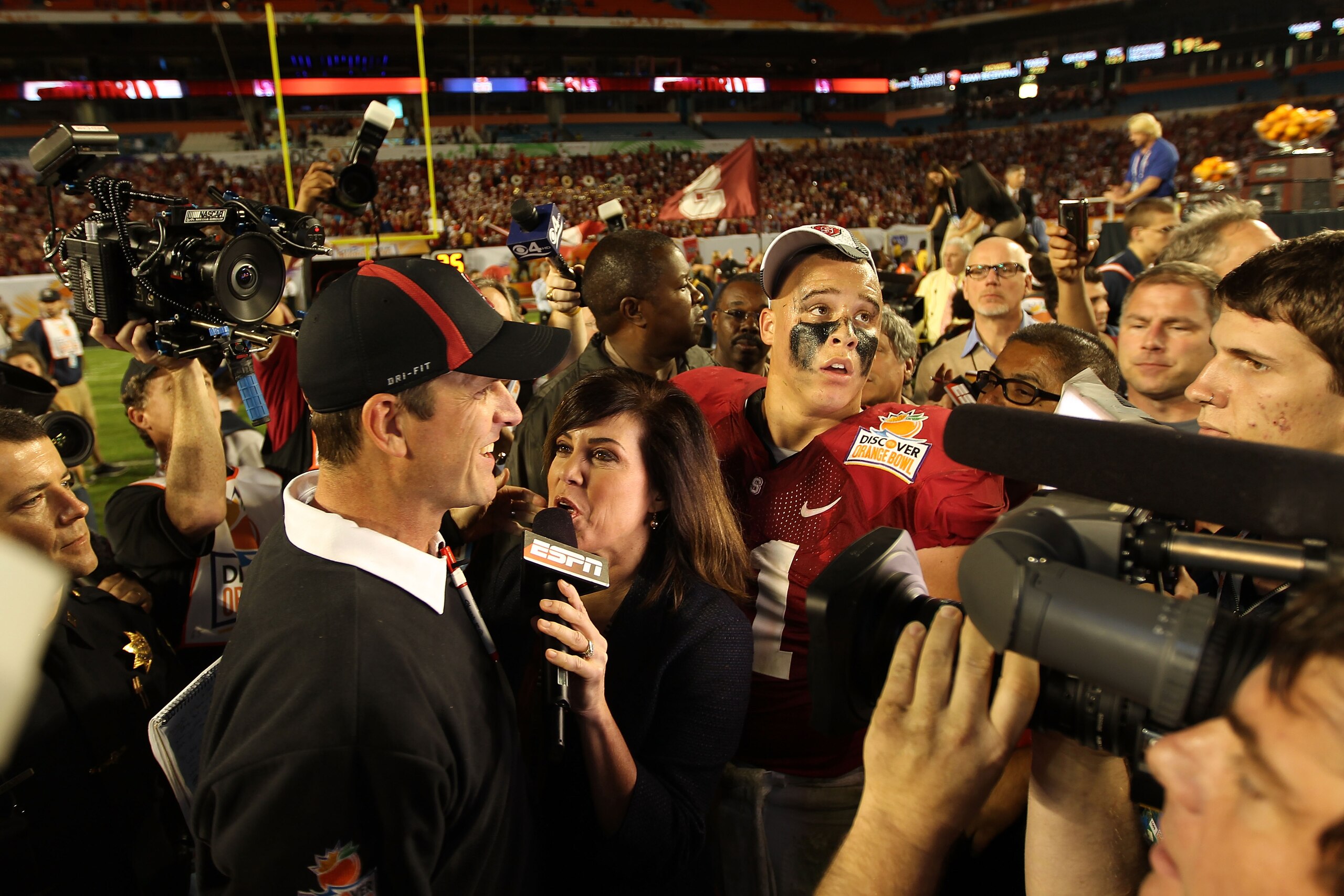 MIAMI, FL - JANUARY 03: Head coach Jim Harbaugh of the Stanford Cardinal is interviewed by ESPN's Michelle Tafoya after Stanford won 40-12 against the Virginia Tech Hokies during the 2011 Discover Orange Bowl at Sun Life Stadium on January 3, 2011 in Miam MIAMI, FL - JANUARY 03: Head coach Jim Harbaugh of the Stanford Cardinal is interviewed by ESPN's Michelle Tafoya after Stanford won 40-12 against the Virginia Tech Hokies during the 2011 Discover Orange Bowl at Sun Life Stadium on January 3, 2011 in Miam