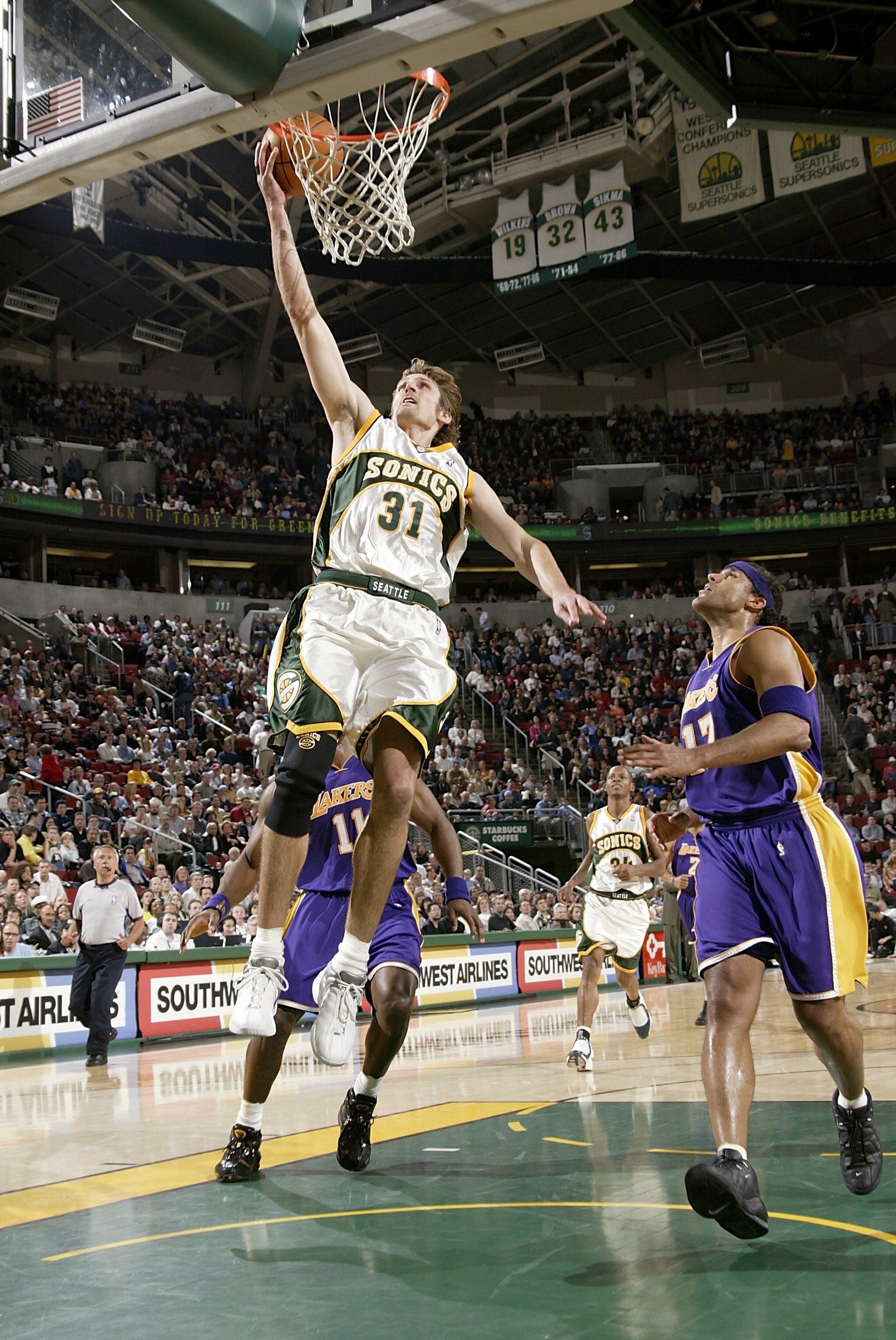 SEATTLE - APRIL 2:  Brent Barry #31 of the Seattle Sonics dunks the ball next to Rick Fox #17 of the Los Angeles Lakers during the game on April 2, 2004 at Key Arena in Seattle, Washington.  The Lakers won 97-86.  NOTE TO USER: User expressly acknowledges
