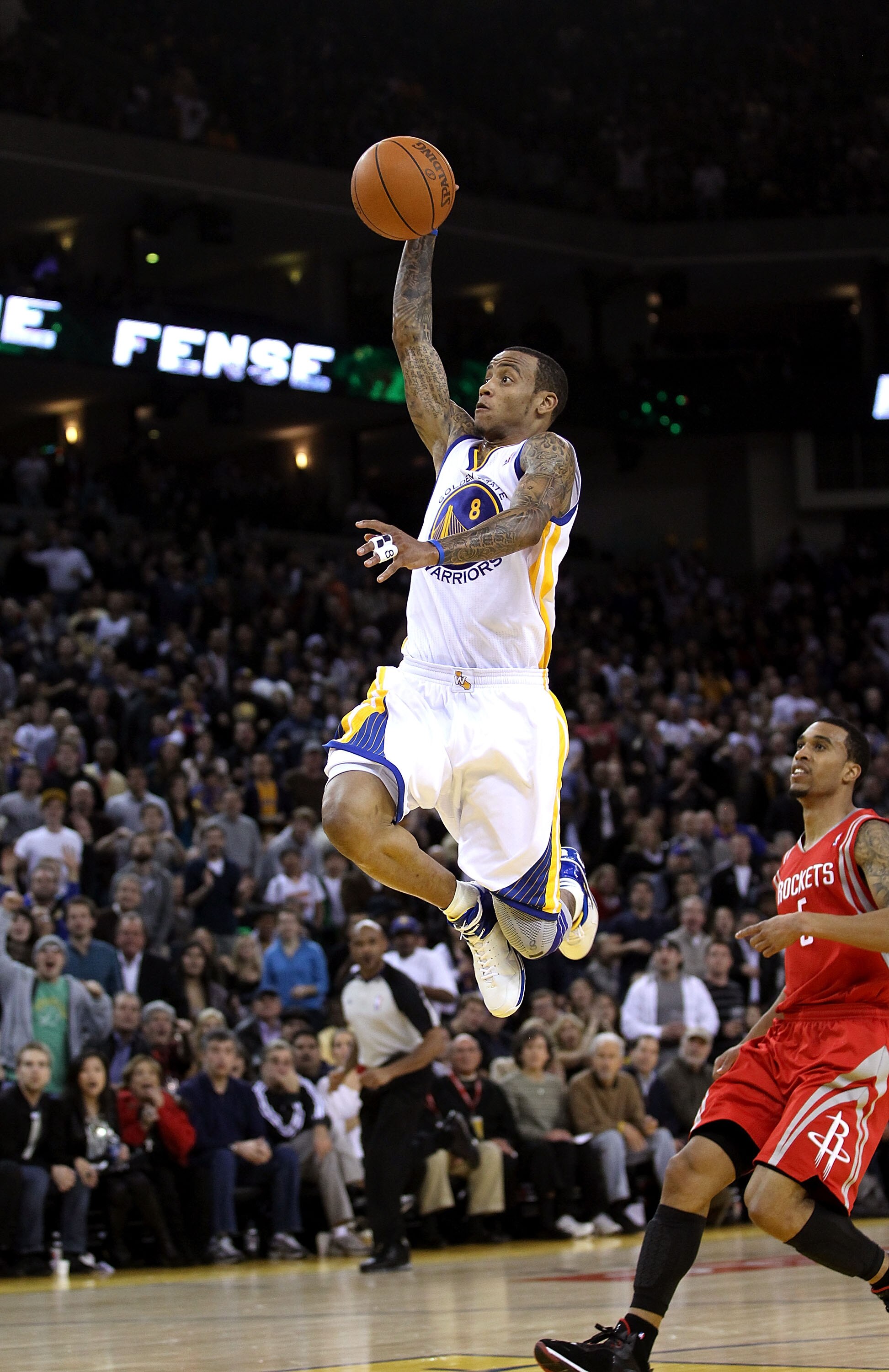 OAKLAND, CA - DECEMBER 20:  Monta Ellis #8 of the Golden State Warriors dunks the ball over Courtney Lee #5 of the Houston Rockets at Oracle Arena on December 20, 2010 in Oakland, California. NOTE TO USER: User expressly acknowledges and agrees that, by d
