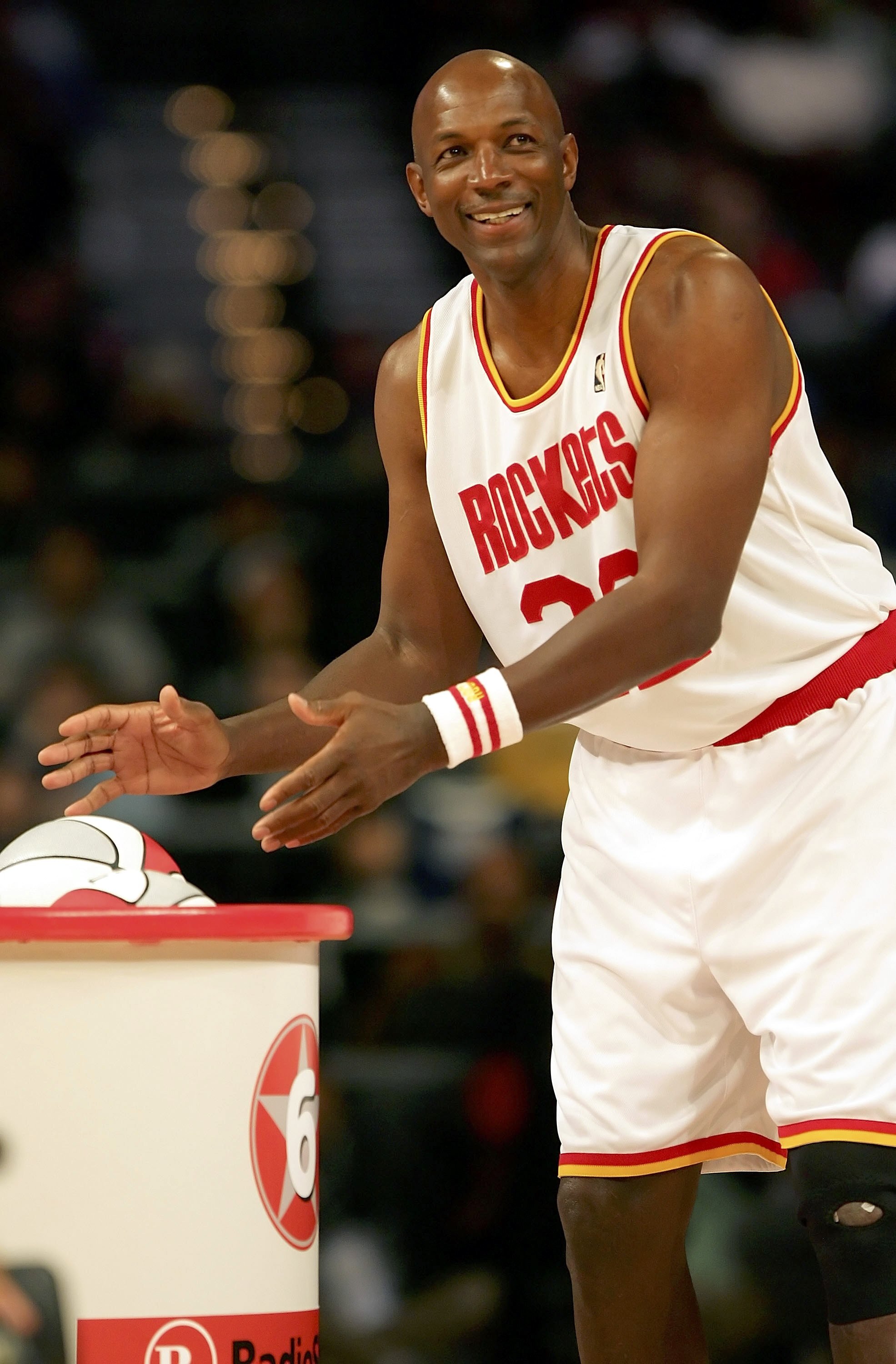 HOUSTON - FEBRUARY 18:  Clyde Drexler #22 of the Houston team smiles as he reaches for a ball in the Radio Shack Shooting Stars competition during NBA All-Star Weekend at the Toyota Center on February 18, 2006 in Houston, Texas.  NOTE TO USER: User expres