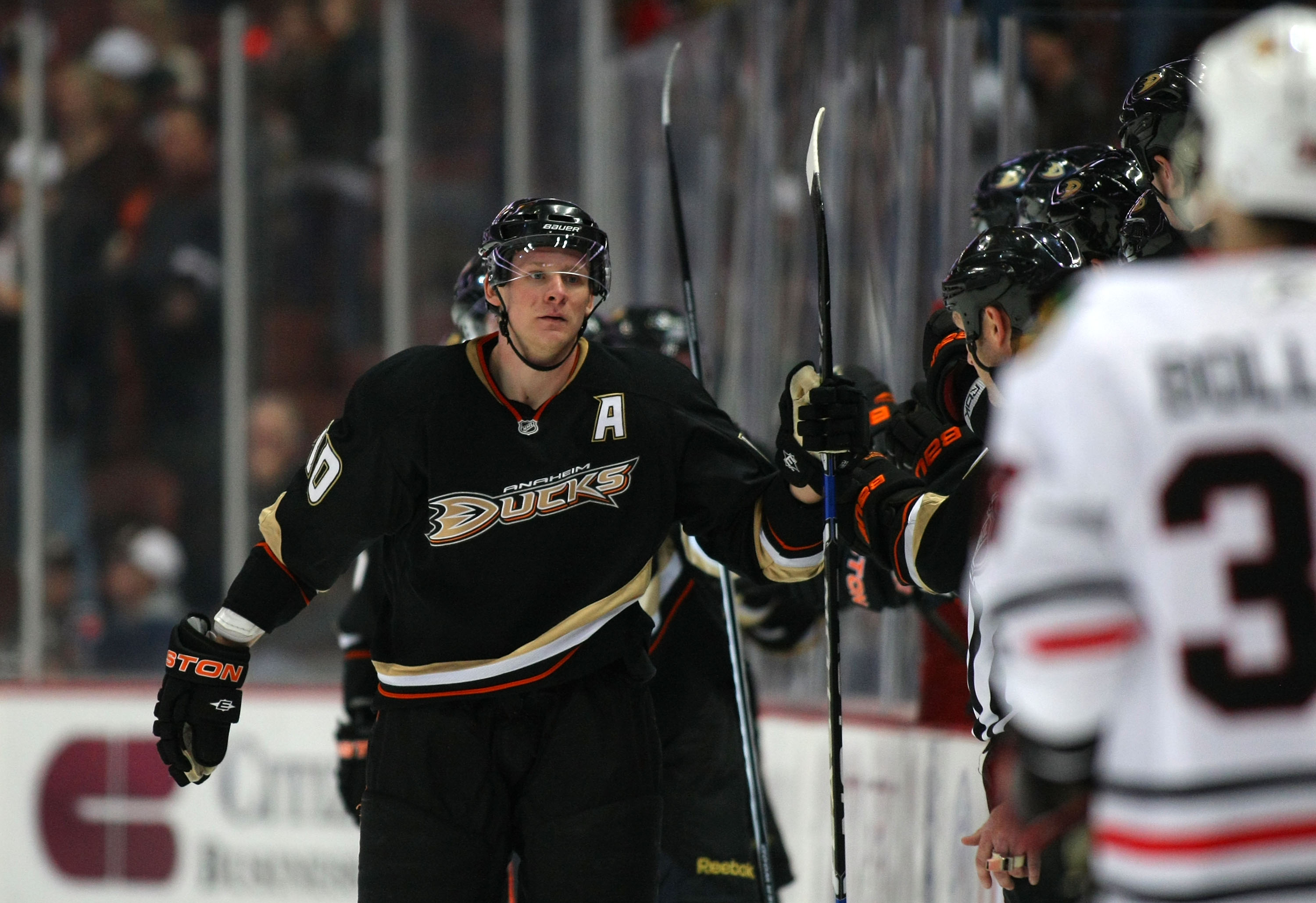 ANAHEIM, CA - JANUARY 02:  Corey Perry #10 of the Anaheim Ducks skates by the Ducks bench to celebrate his second period goal as David Bolland #36 of the Chicago Blackhawks looks on during the NHL game at Honda Center on January 2, 2011 in Anaheim, Califo