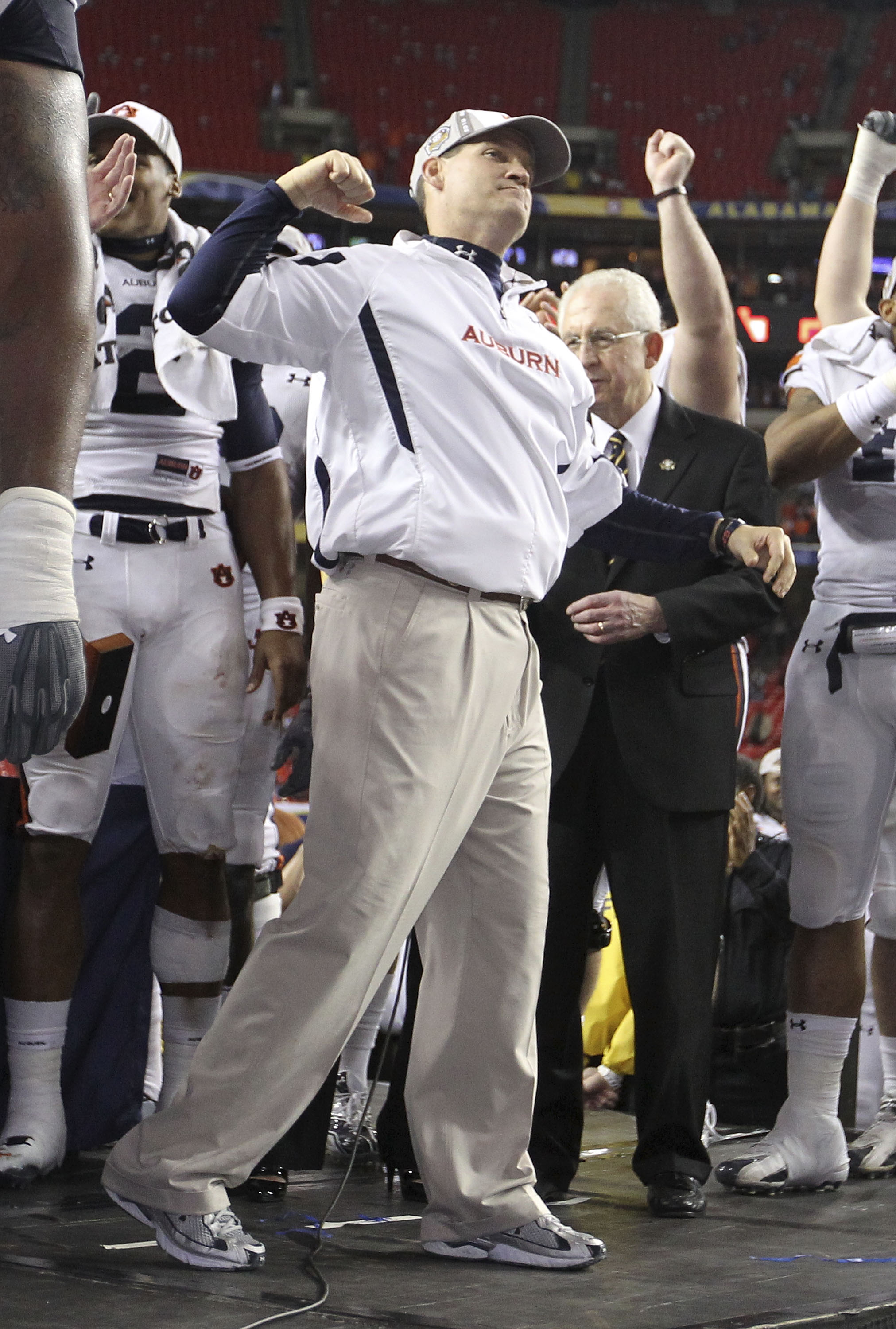 ATLANTA - DECEMBER 4:  Head coach Gene Chizik of the Auburn Tigers celebrates on the podium after the 2010 SEC Championship against the South Carolina Gamecocks at Georgia Dome on December 4, 2010 in Atlanta, Georgia. The Tigers beat the Gamecocks 56-17.