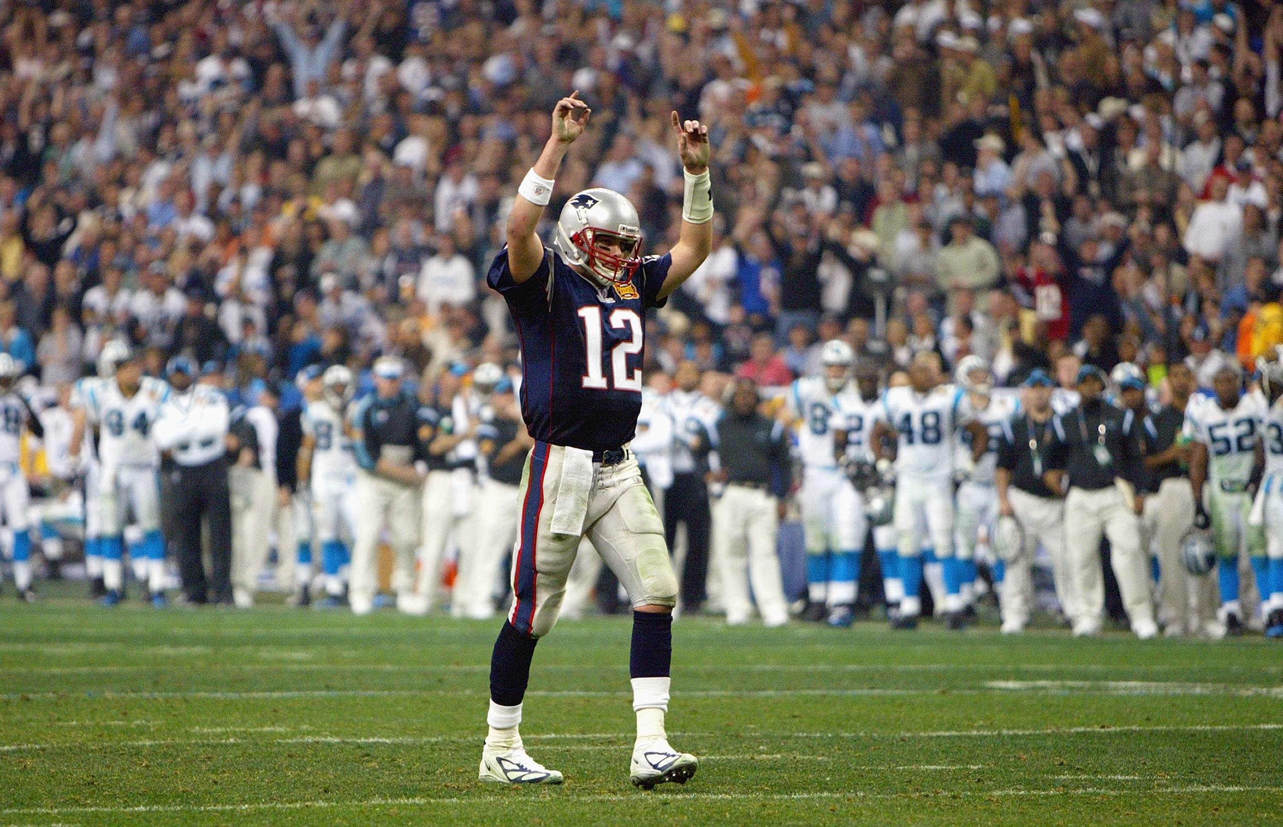 HOUSTON - FEBRUARY 1:  Quarterback Tom Brady #12 of the New England Patriots raises his arms in celebration of a play against the Carolina Panthers during Super Bowl XXXVIII at Reliant Stadium on February 1, 2004 in Houston, Texas.  The Patriots defeated