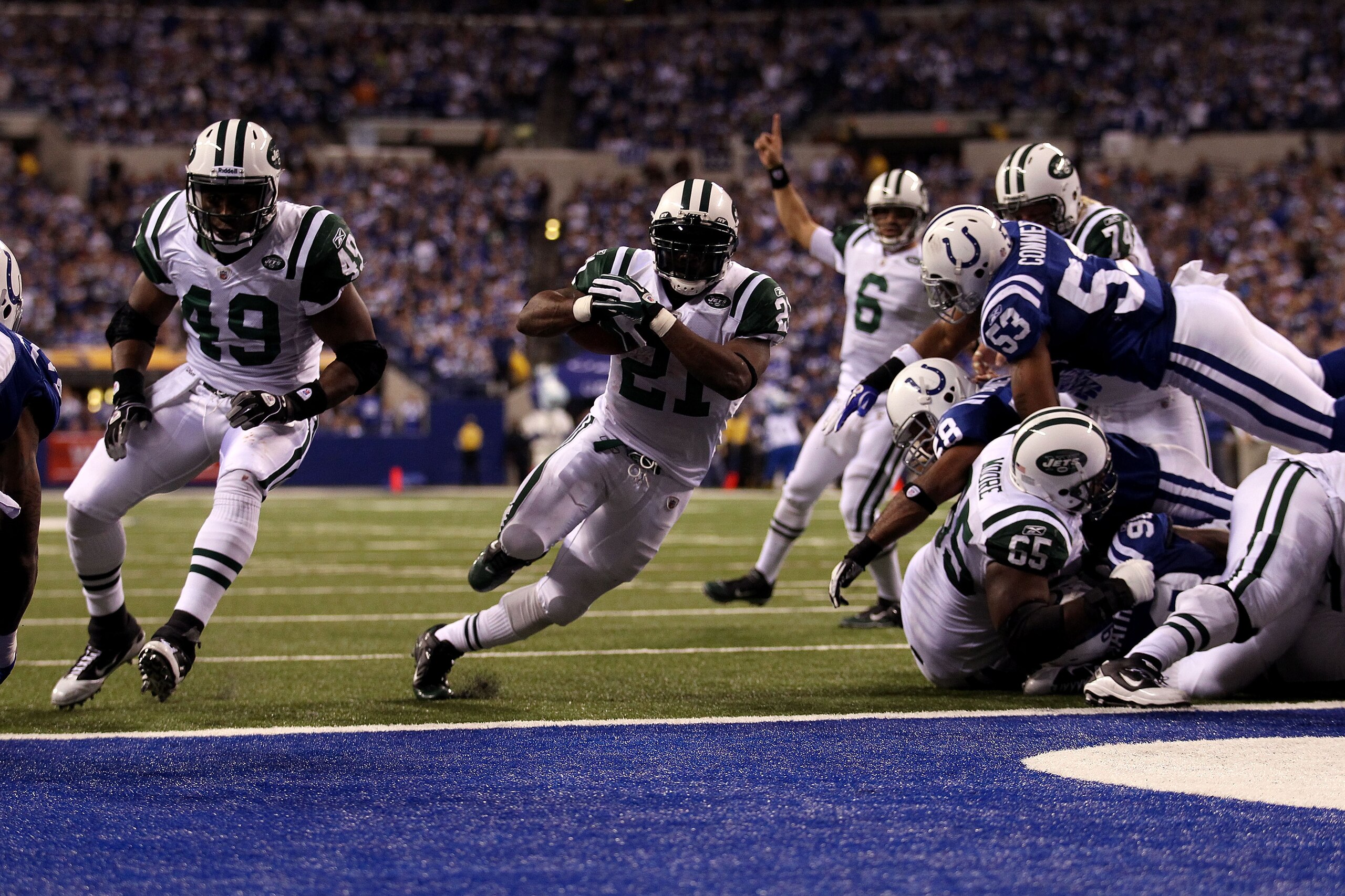 INDIANAPOLIS, IN - JANUARY 08:  LaDainian Tomlinson #21 of the New York Jets scores 1-yard rushing touchdown in the fourth quarter as quarterback Mark Sanchez celebrates in the background against the Indianapolis Colts during their 2011 AFC wild card play