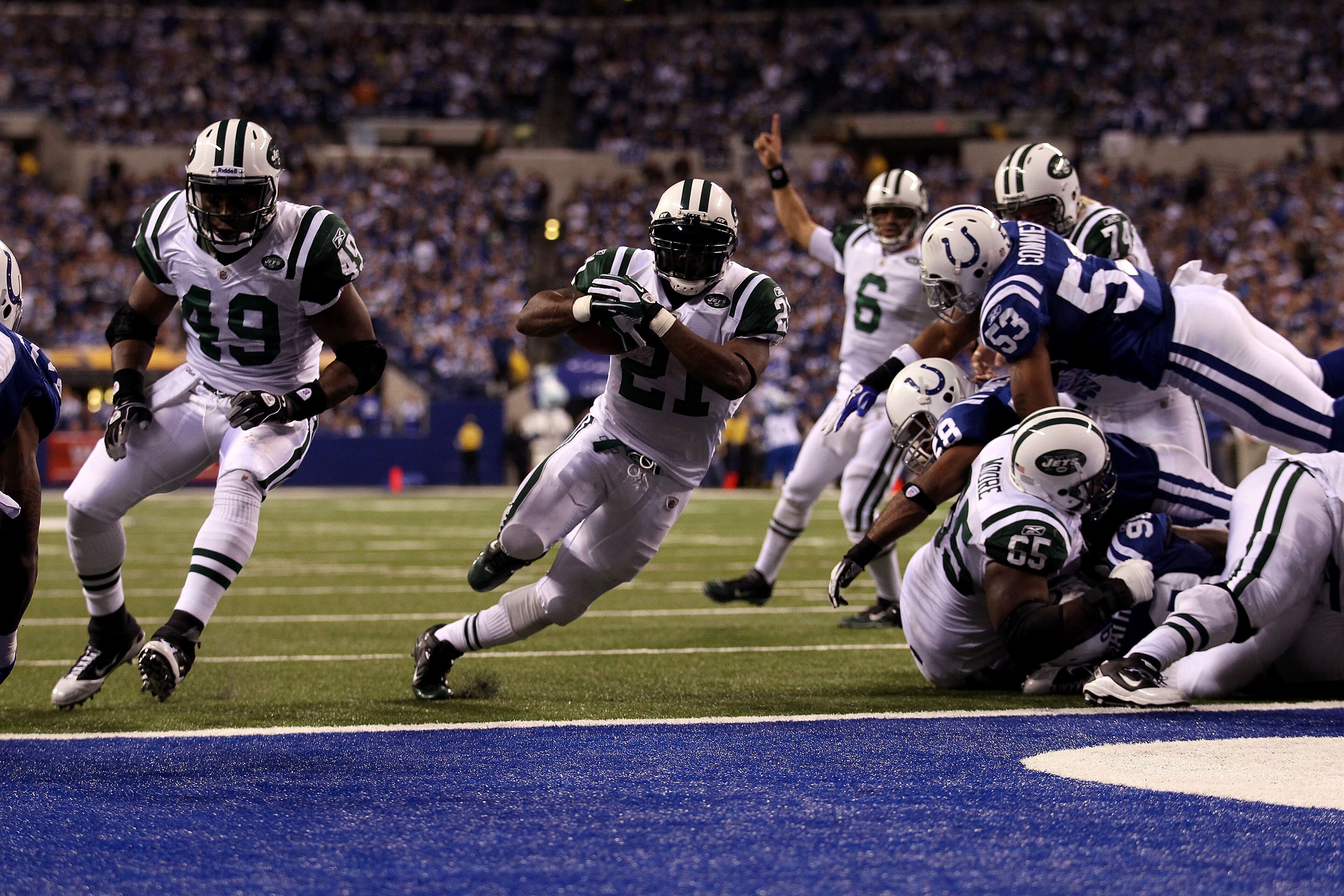 INDIANAPOLIS, IN - JANUARY 08:  LaDainian Tomlinson #21 of the New York Jets scores 1-yard rushing touchdown in the fourth quarter as quarterback Mark Sanchez celebrates in the background against the Indianapolis Colts during their 2011 AFC wild card play