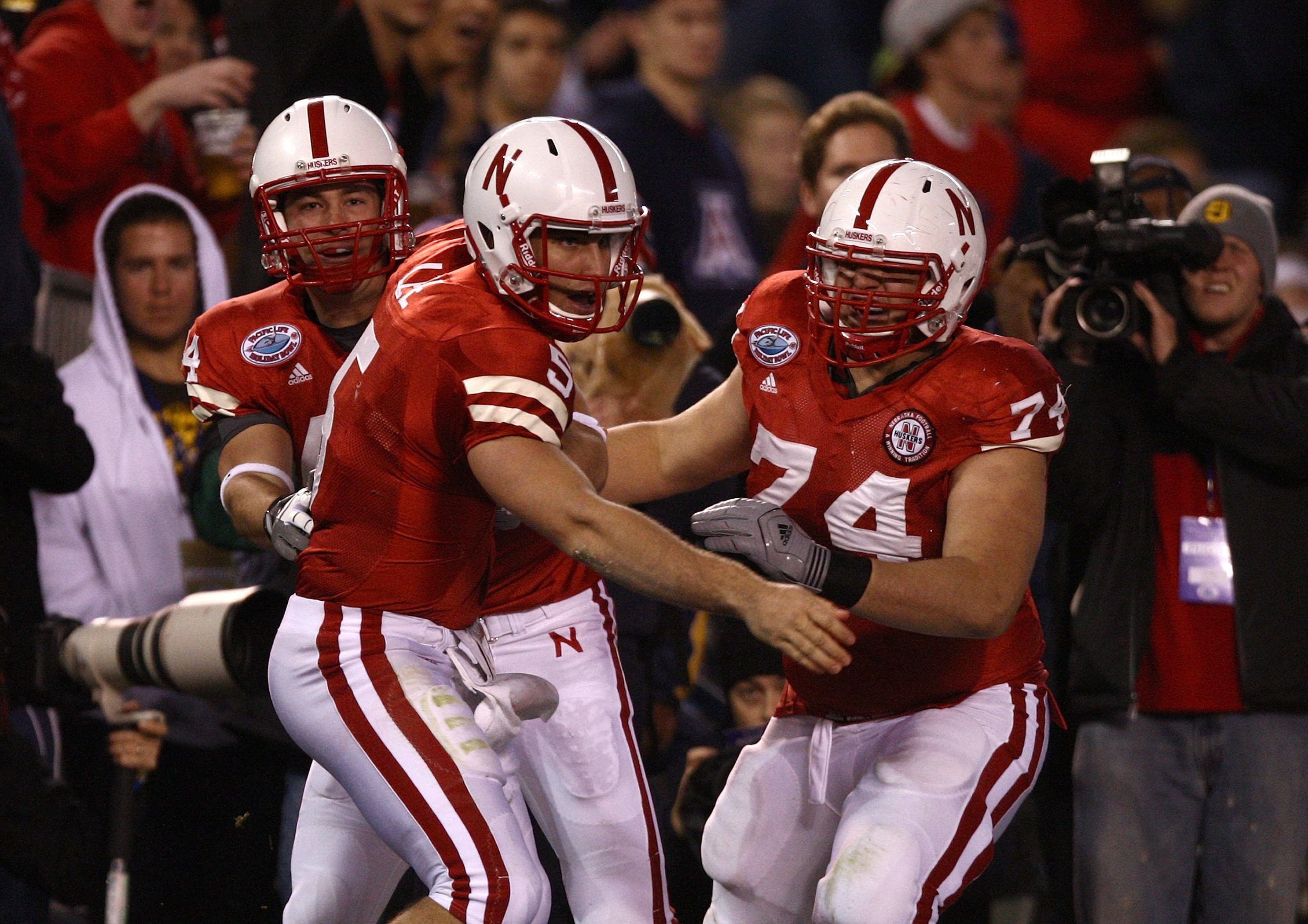 SAN DIEGO - DECEMBER 30:  Quarterback Zac Lee #5 of the University of Nebraska Cornhuskers is mobbed by teammates after scoring the first touchdown against the University of Arizona Wildcats during the Pacific Life Holiday Bowl on December 30, 2009 at Qua