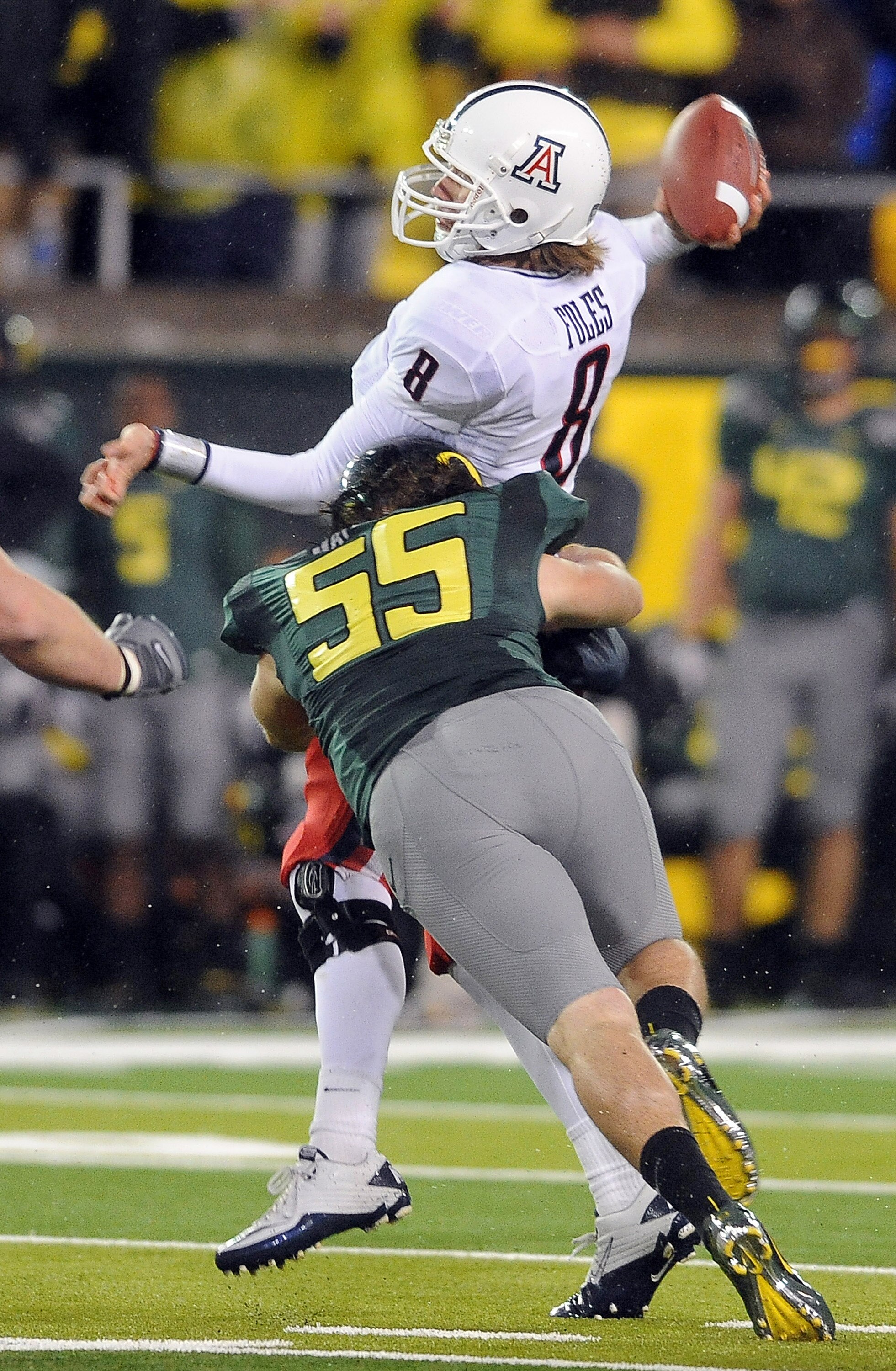 EUGENE, OR - NOVEMBER 26: Quarterback Nick Foles #8 of the Arizona Wildcats is hit by linebacker Casey Matthews #55 of the Oregon Ducks as he throws a pass in the third quarter of the game at Autzen Stadium on November 26, 2010 in Eugene, Oregon.The Ducks