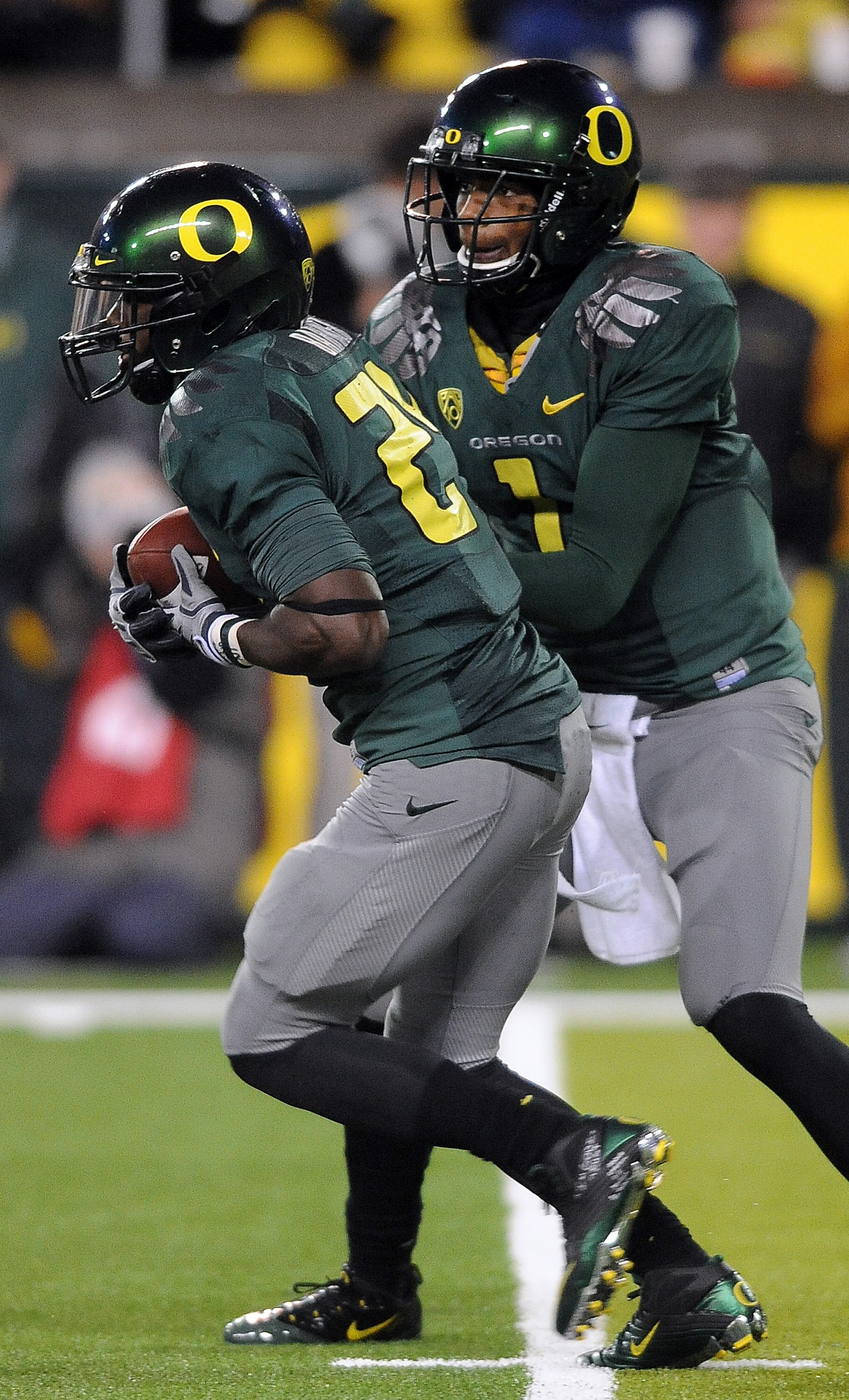 EUGENE, OR - NOVEMBER 26: Quarterback Darron Thomas #1 hands the ball off to running back Kenjon Barner #24 of the Oregon Ducks in the fourth quarter of the game against the Arizona Wildcats at Autzen Stadium on November 26, 2010 in Eugene, Oregon. The Du