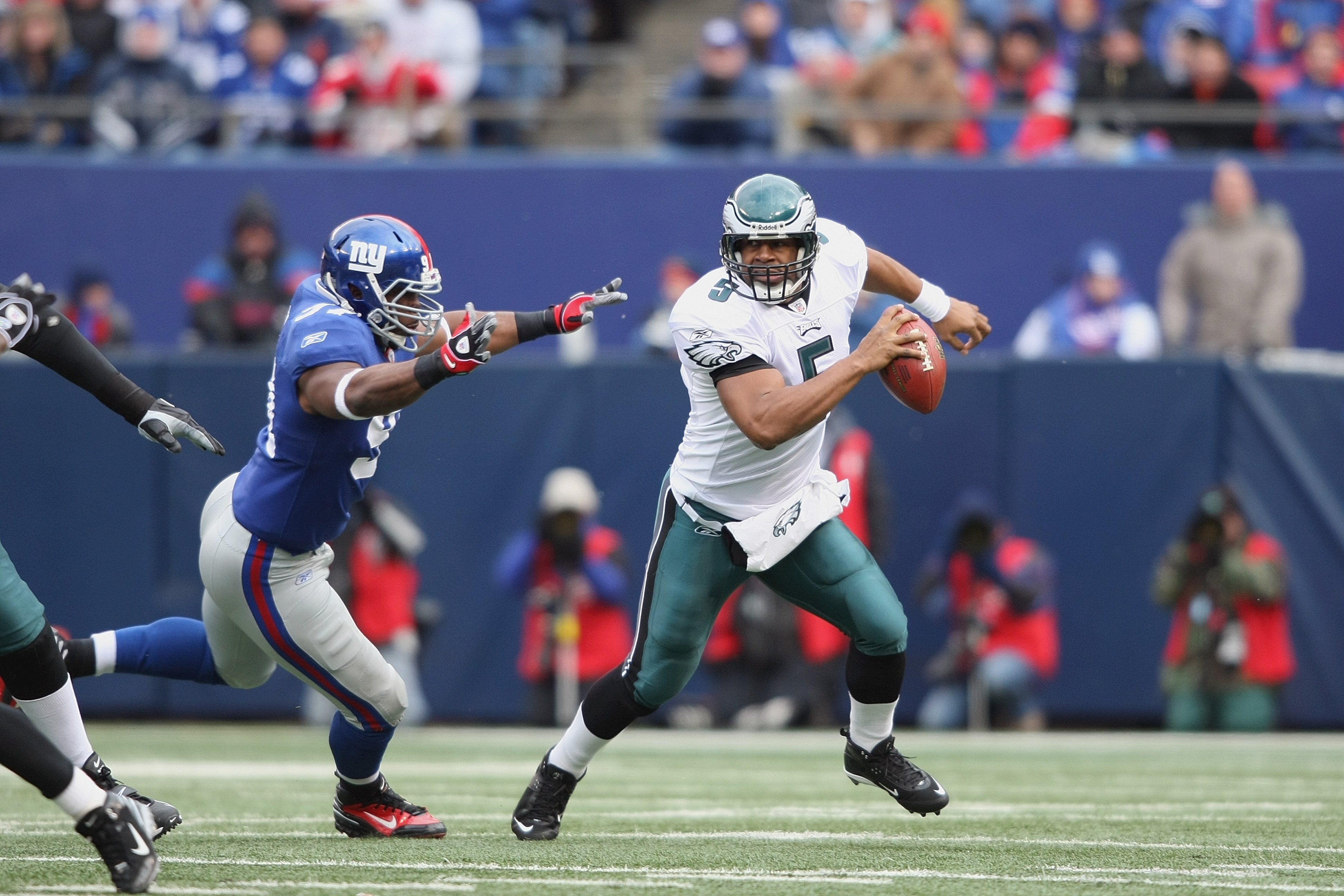 EAST RUTHERFORD, NJ - DECEMBER 7:  Quarterback Donovan McNabb #5 of the Philadelphia Eagles scrambles as he looks to pass the ball against Justin Tuck #91 of the New York Giants at Giants Stadium on December 7, 2008 in East Rutherford, New Jersey. (Photo
