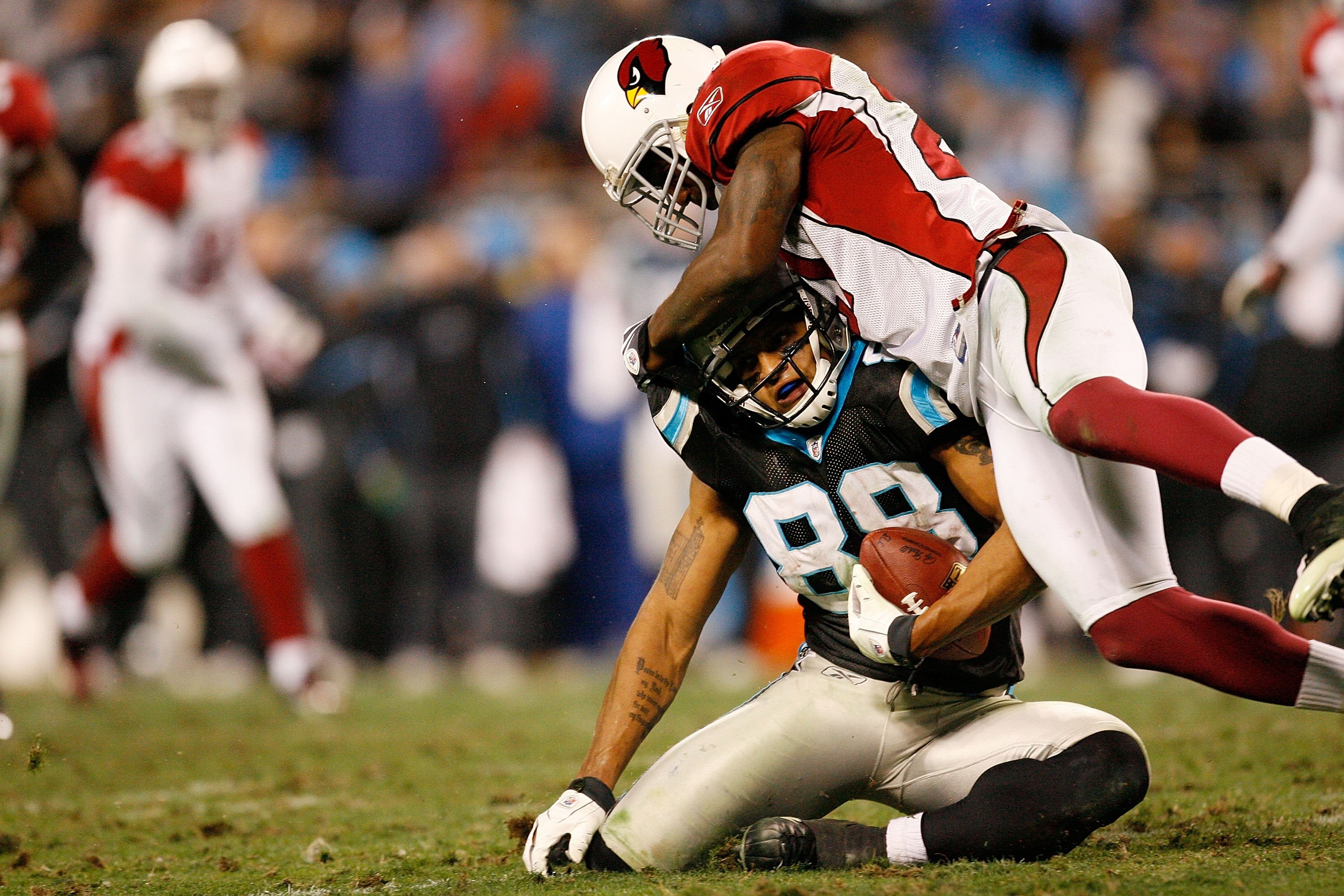 CHARLOTTE, NC - JANUARY 10: Dante Rosario #88 of the Carolina Panthers is tackled by Antrel Rolle #21 of the Arizona Cardinals during the NFC Divisional Playoff Game on January 10, 2009 at Bank of America Stadium in Charlotte, North Carolina.  (Photo by K