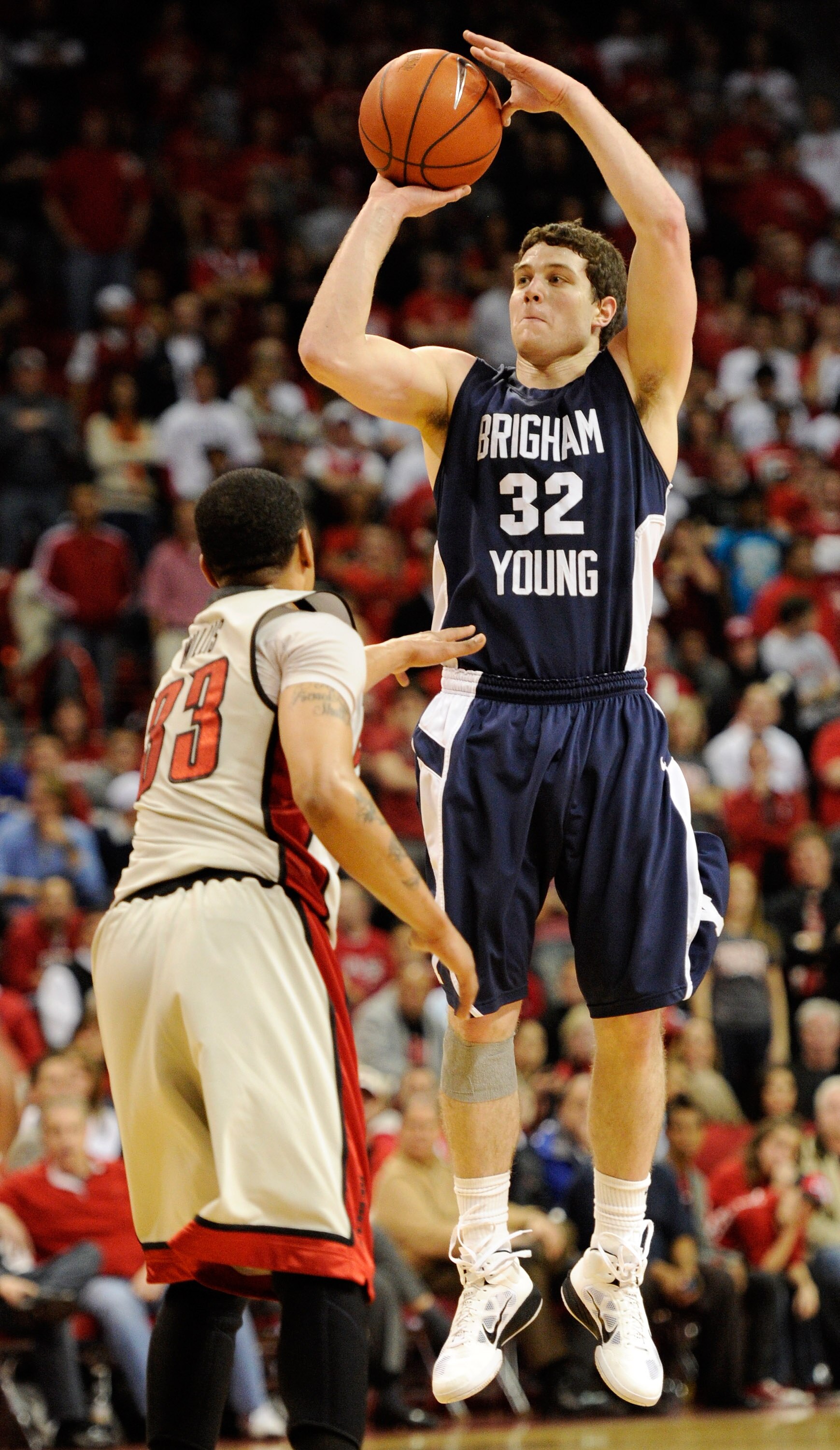 LAS VEGAS, NV - JANUARY 05:  Jimmer Fredette #32 of the Brigham Young University Cougars shoots over Tre'Von Willis #33 of the UNLV Rebels during their game at the Thomas & Mack Center January 5, 2011 in Las Vegas, Nevada. BYU won 89-77.  (Photo by Ethan 