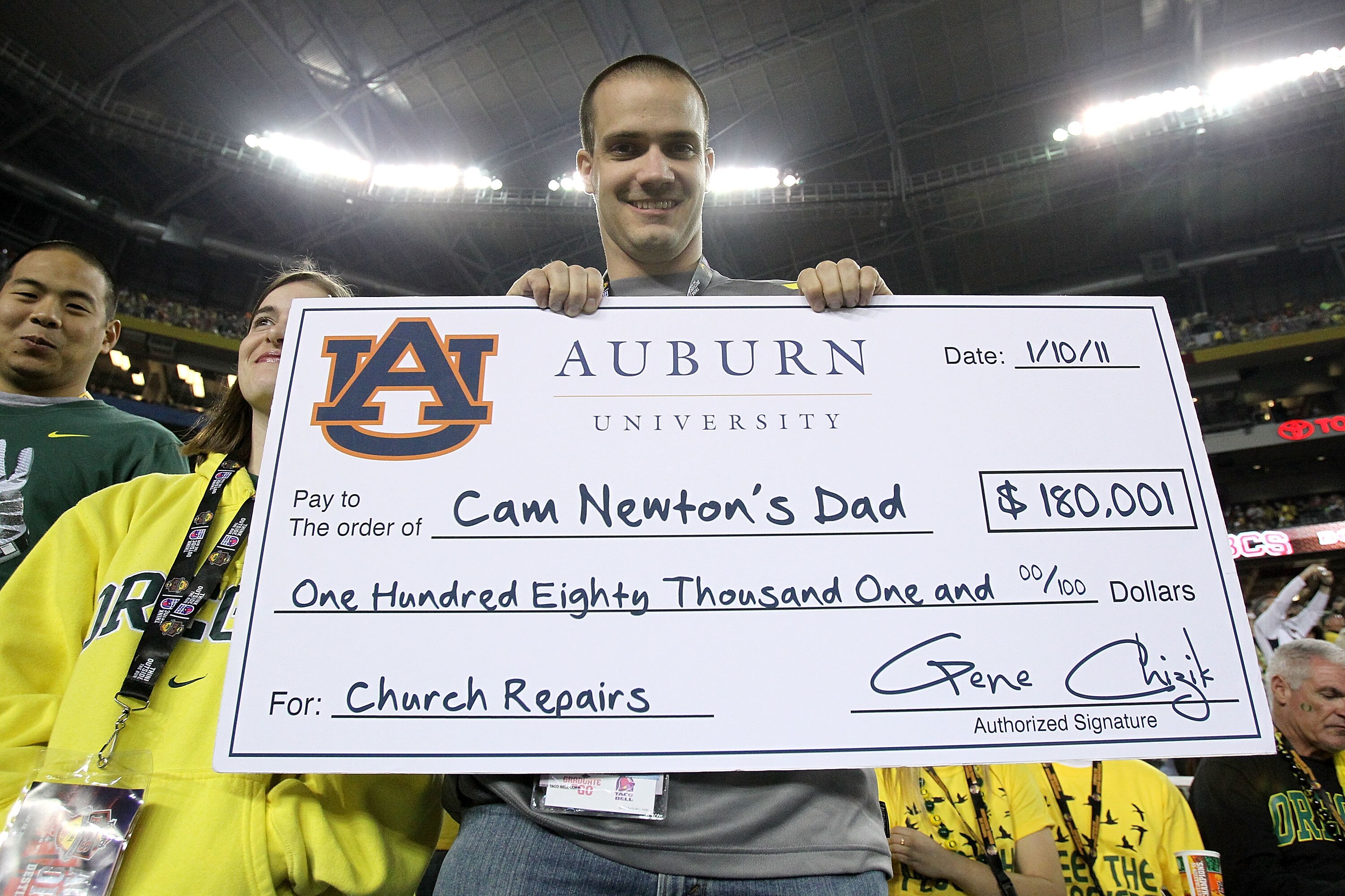 GLENDALE, AZ - JANUARY 10:  An Oregon Ducks fan holds up a fake check in reference to Auburn Tigers quarterback Cameron Newton before the Tostitos BCS National Championship Game at University of Phoenix Stadium on January 10, 2011 in Glendale, Arizona.  (
