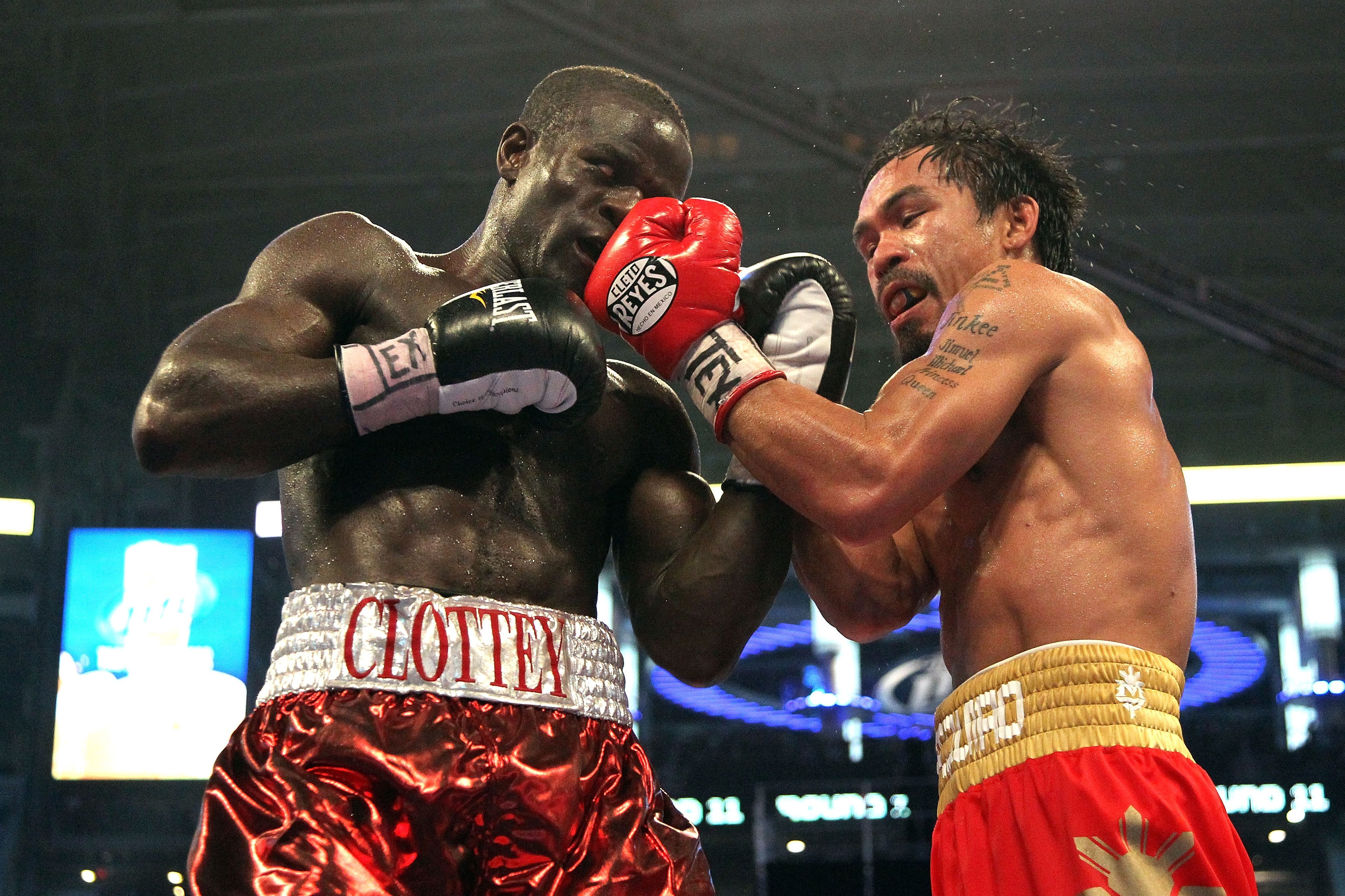 ARLINGTON, TX - MARCH 13:  (R-L) Manny Pacquiao of the Philippines throws a left to the head of Joshua Clottey of Ghana during the WBO welterweight title fight at Cowboys Stadium on March 13, 2010 in Arlington, Texas. Pacquiao defeated Clottey by unanimou