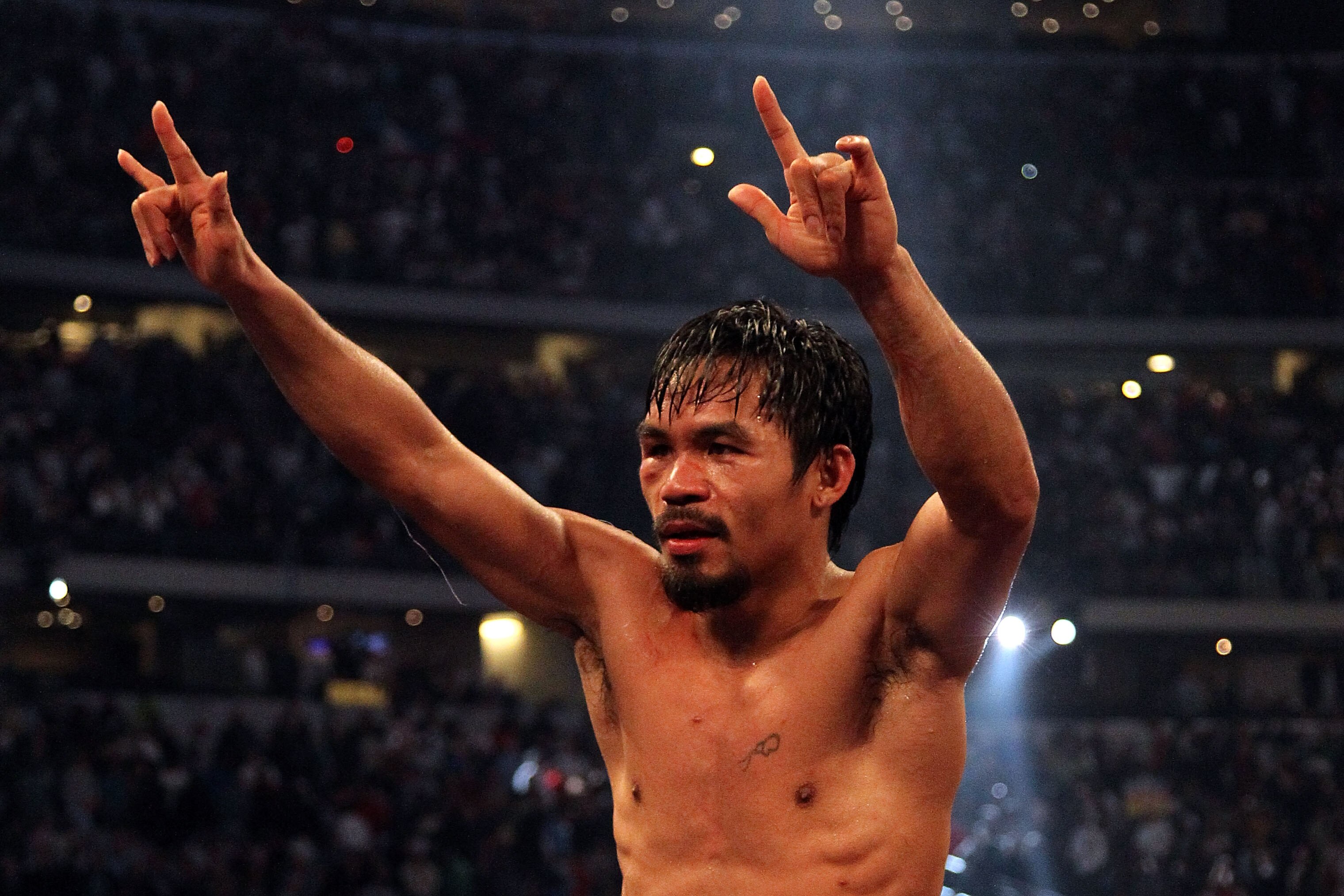 ARLINGTON, TX - MARCH 13:  Manny Pacquiao of the Philippines celebrates in the ring after defeating Joshua Clottey of Ghana during the WBO welterweight title fight at Cowboys Stadium on March 13, 2010 in Arlington, Texas. Pacquiao defeated Clottey by unan
