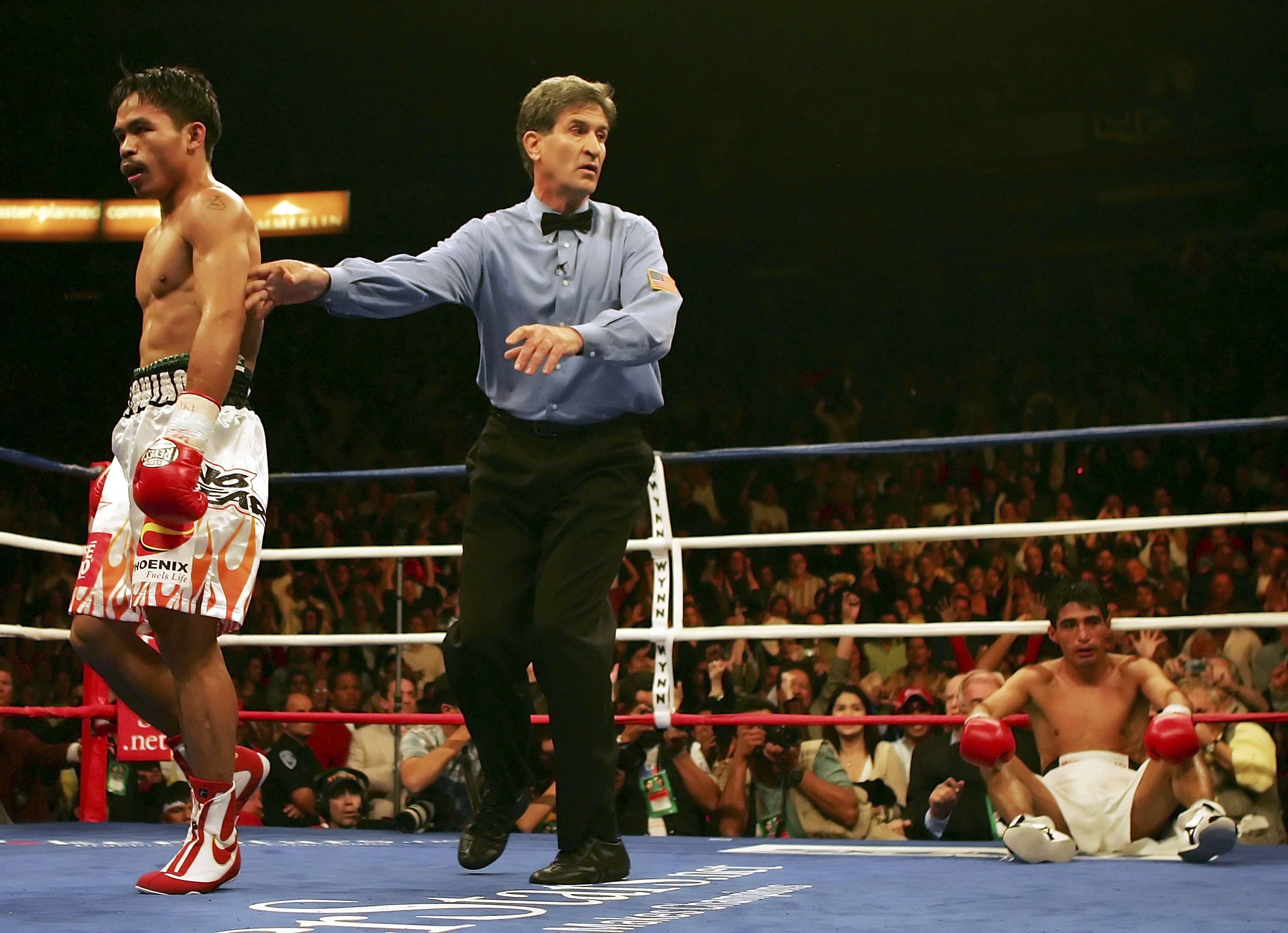 LAS VEGAS - NOVEMBER 18:  (L-R) Manny Pacquiao of the Philippines is directed to his corner by referee Vic Drakulich as Erik Morales of Mexico is knocked down for the second time in round three during their super featherweight bout at the Thomas & Mack Ce