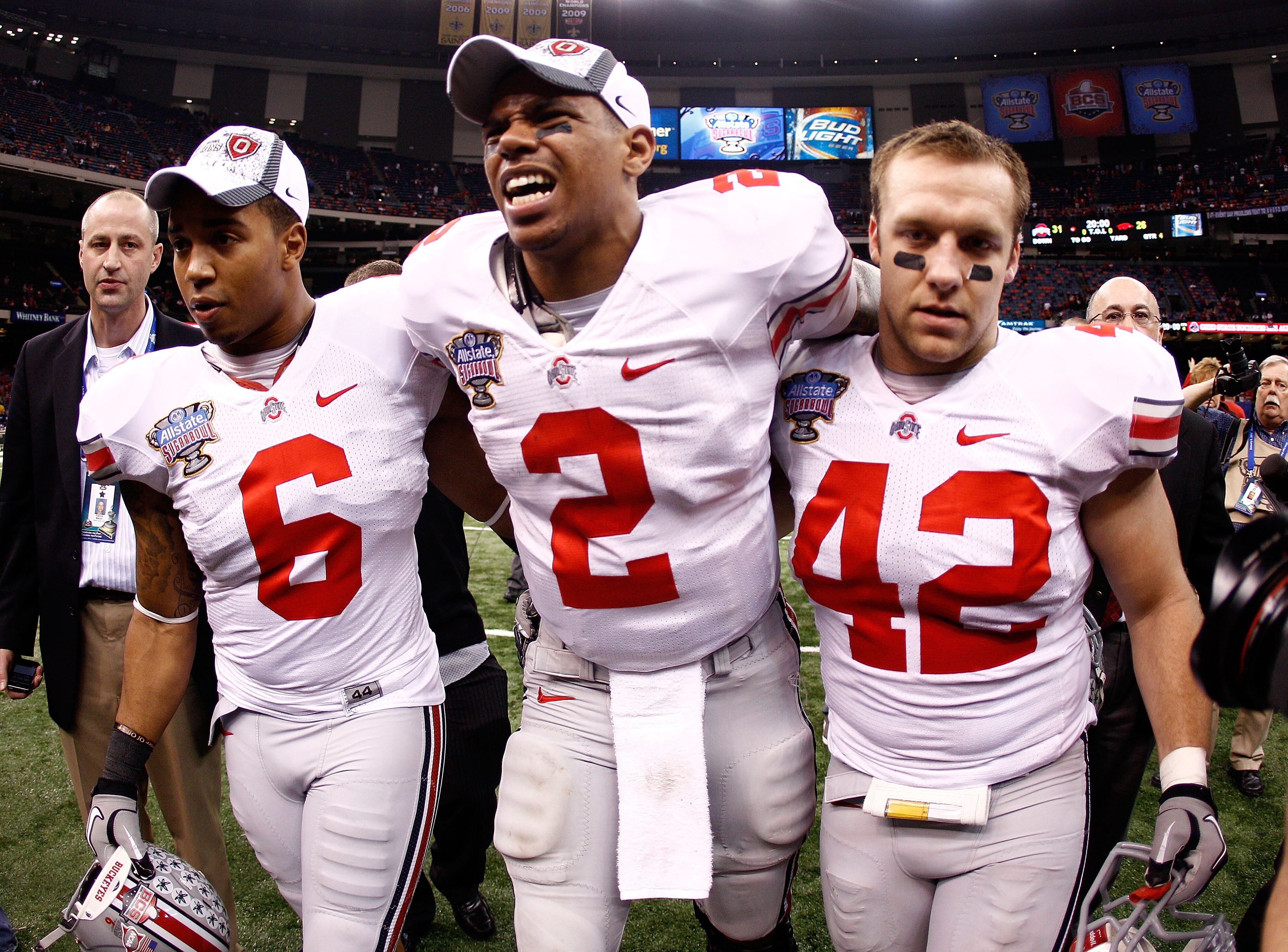 NEW ORLEANS, LA - JANUARY 04:  (M) Quarterback Terrelle Pryor #2 of the Ohio State Buckeyes is helped off the field by teammates Etienne Sabino #6 and Andrew Sweat #42 after the Buckeyes 31-26 victory against the Arkansas Razorbacks during the Allstate Su