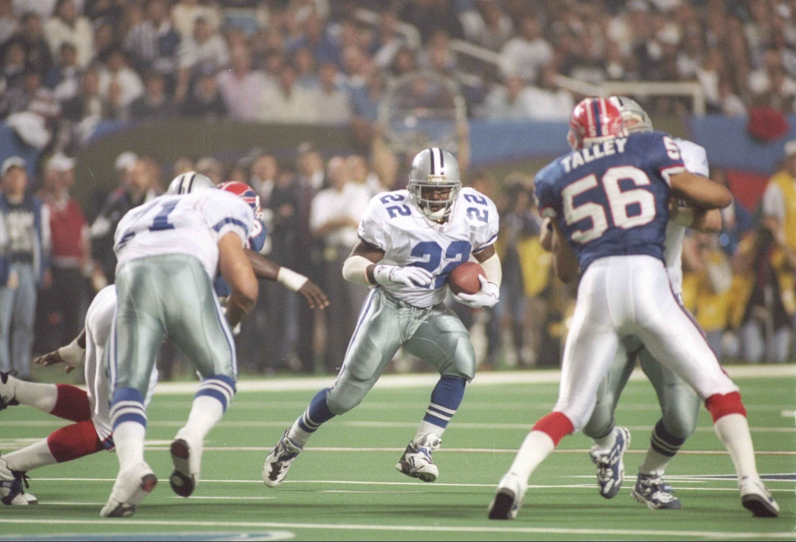30 Jan 1994:  Running back Emmitt Smith #22 of the Dallas Cowboys dodges as he charges downfield with the ball during Super Bowl XXVIII against the Buffalo Bills at the Georgia Dome in Atlanta, Georgia .  Smith was named game MVP and  the Cowboys won 30-1