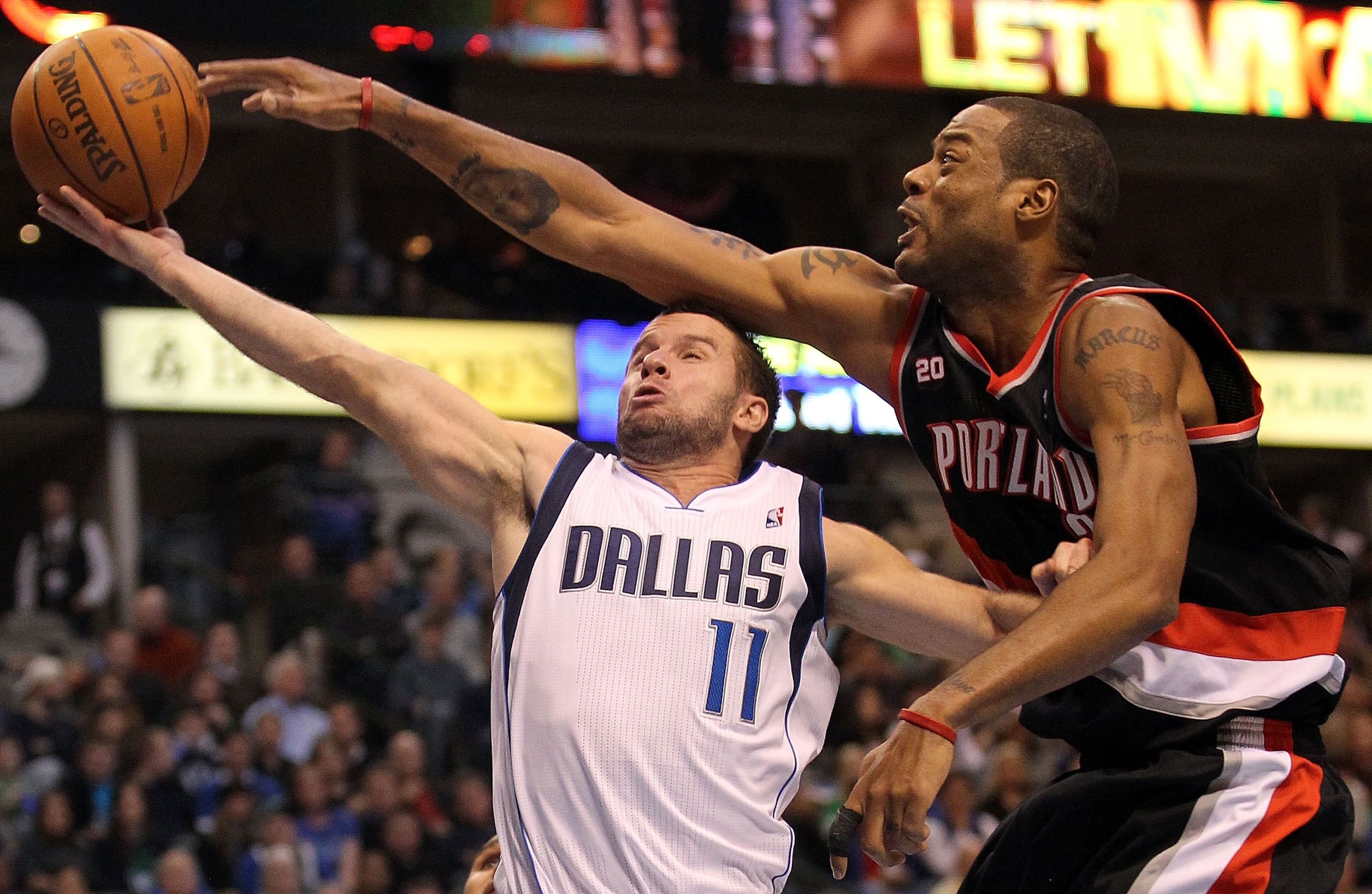 DALLAS, TX - JANUARY 04:  Guard Jose Juan Barea #11 of the Dallas Mavericks takes a shot against Marcus Camby #23 of the Portland Trail Blazers at American Airlines Center on January 4, 2011 in Dallas, Texas.  NOTE TO USER: User expressly acknowledges and