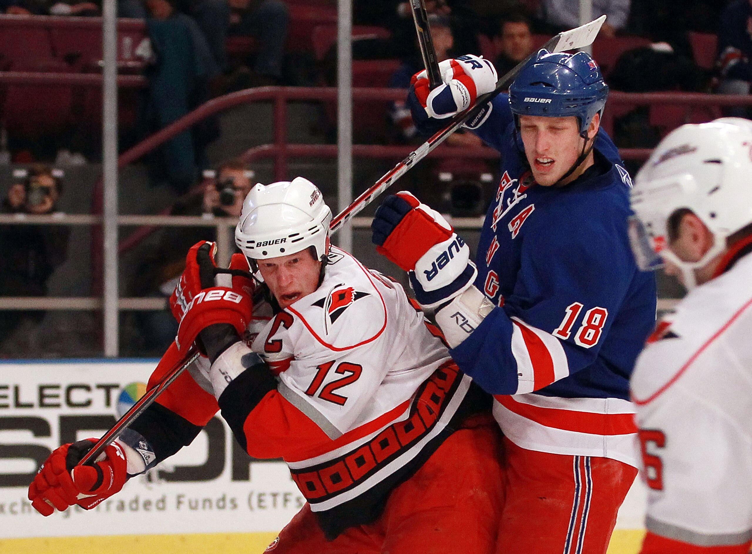NEW YORK, NY - JANUARY 05:  Marc Staal #18 of the New York Rangers ties up his brother Eric Staal #12 of the Carolina Hurricanes at Madison Square Garden on January 5, 2011 in New York   The Rangers defeated the Hurricanes 2-1 in overtime.  (Photo by Bruc