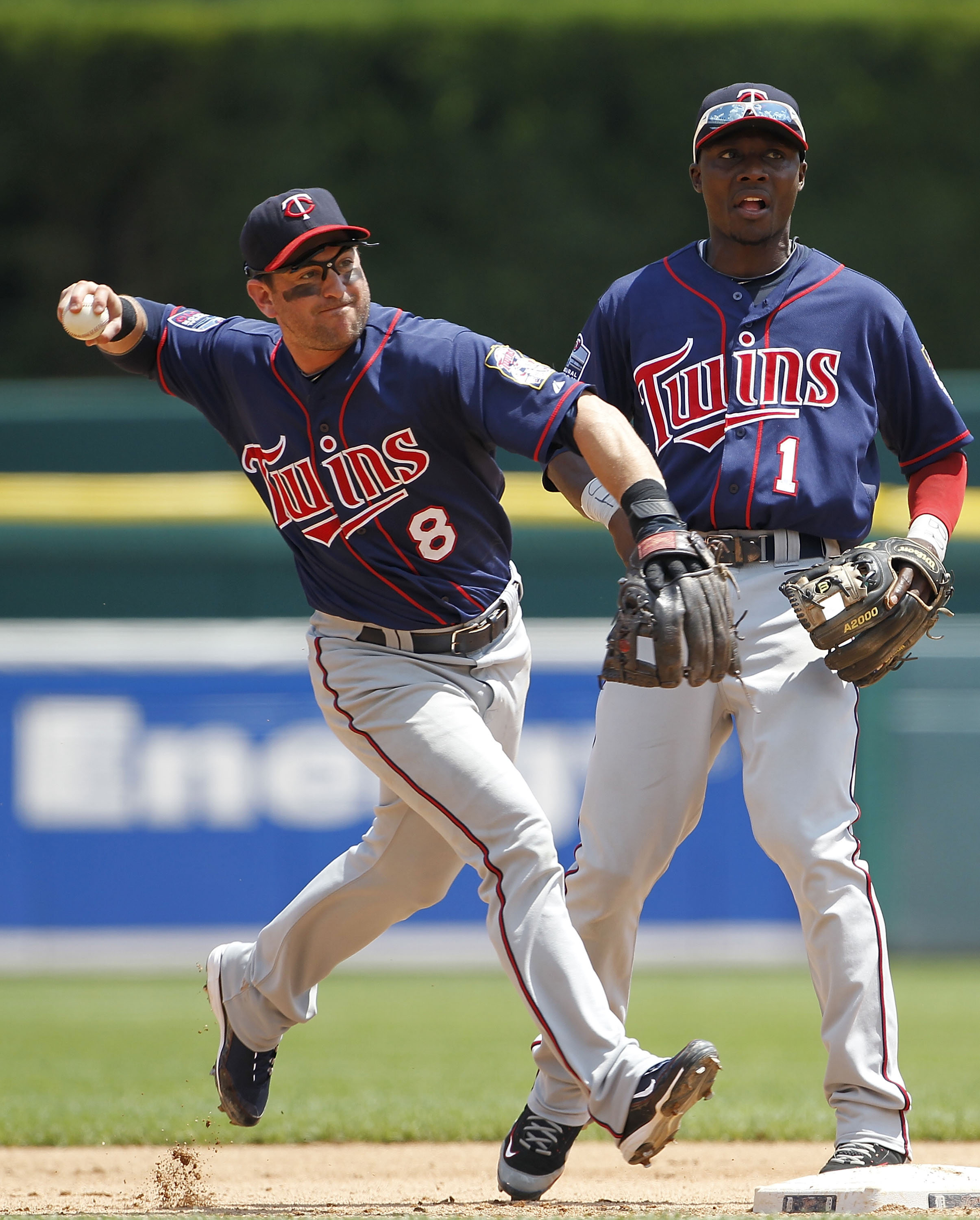 DETROIT - JULY 11: Nick Punto #8 of the Minnesota Twins turns a double play during the fifth inning as teammate Orlando Hudson #1 looks on during the game against the Detroit Tigers on July 11, 2010 at Comerica Park in Detroit, Michigan. The Twins defeate