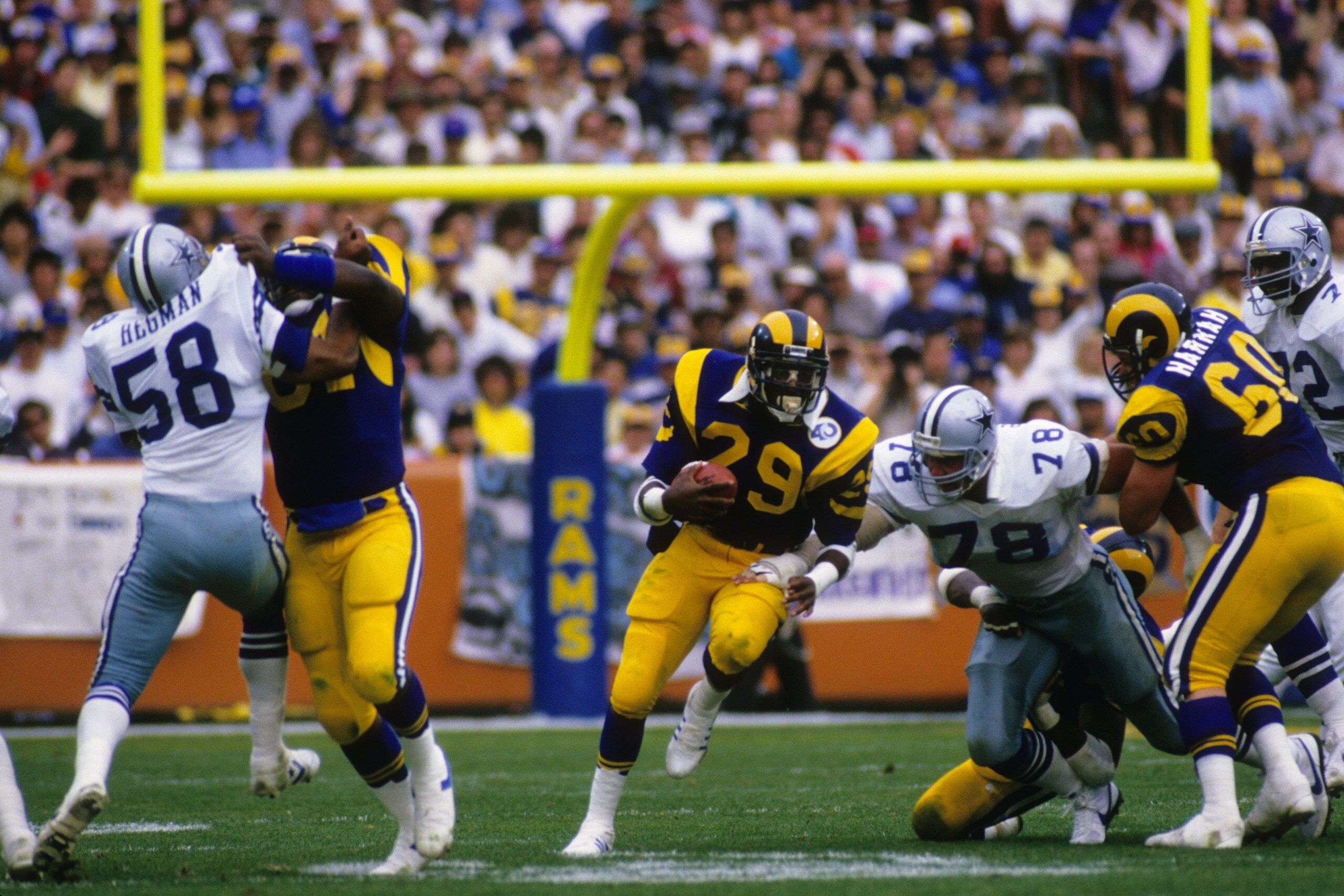 ANAHEIM, CA - JANUARY 4:  Eric Dickerson #28 of the Los Angeles Rams eludes defensive end John Dutton #78 of the Dallas Cowboys as he runs down field during the 1985 NFC Divisional Playoffs at Anaheim Stadium on January 4, 1986 in Anaheim, California.  Th