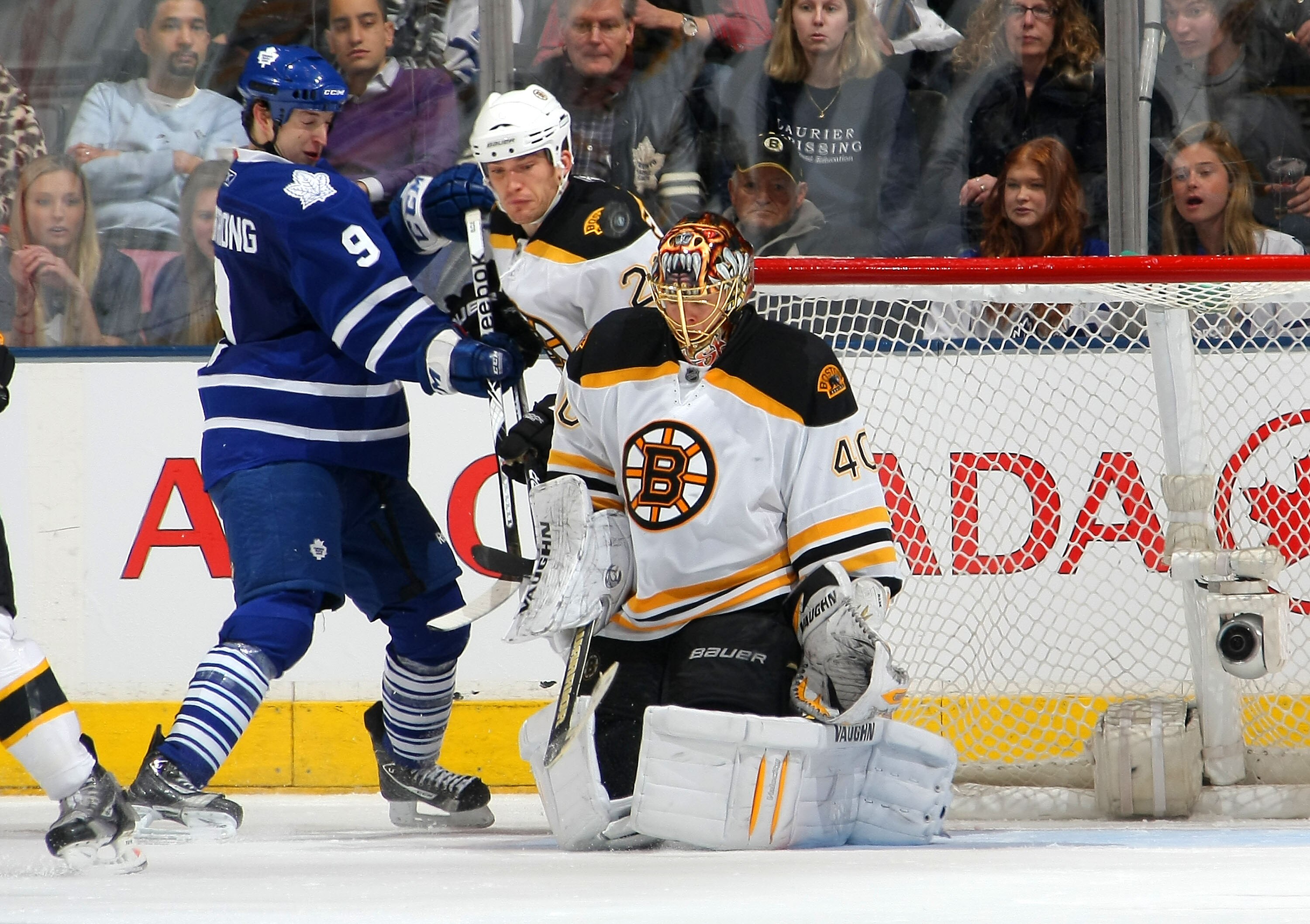 TORONTO,CANADA - JANUARY 3:  Tuukka Rask #40 of the Boston Bruins makes a save as Colby Armstrong #9 of the Toronto Maple Leafs tries to get his stick on a rebound as he battles with Andrew Ference #21 of the Boston Bruins during their NHL game at Air Can