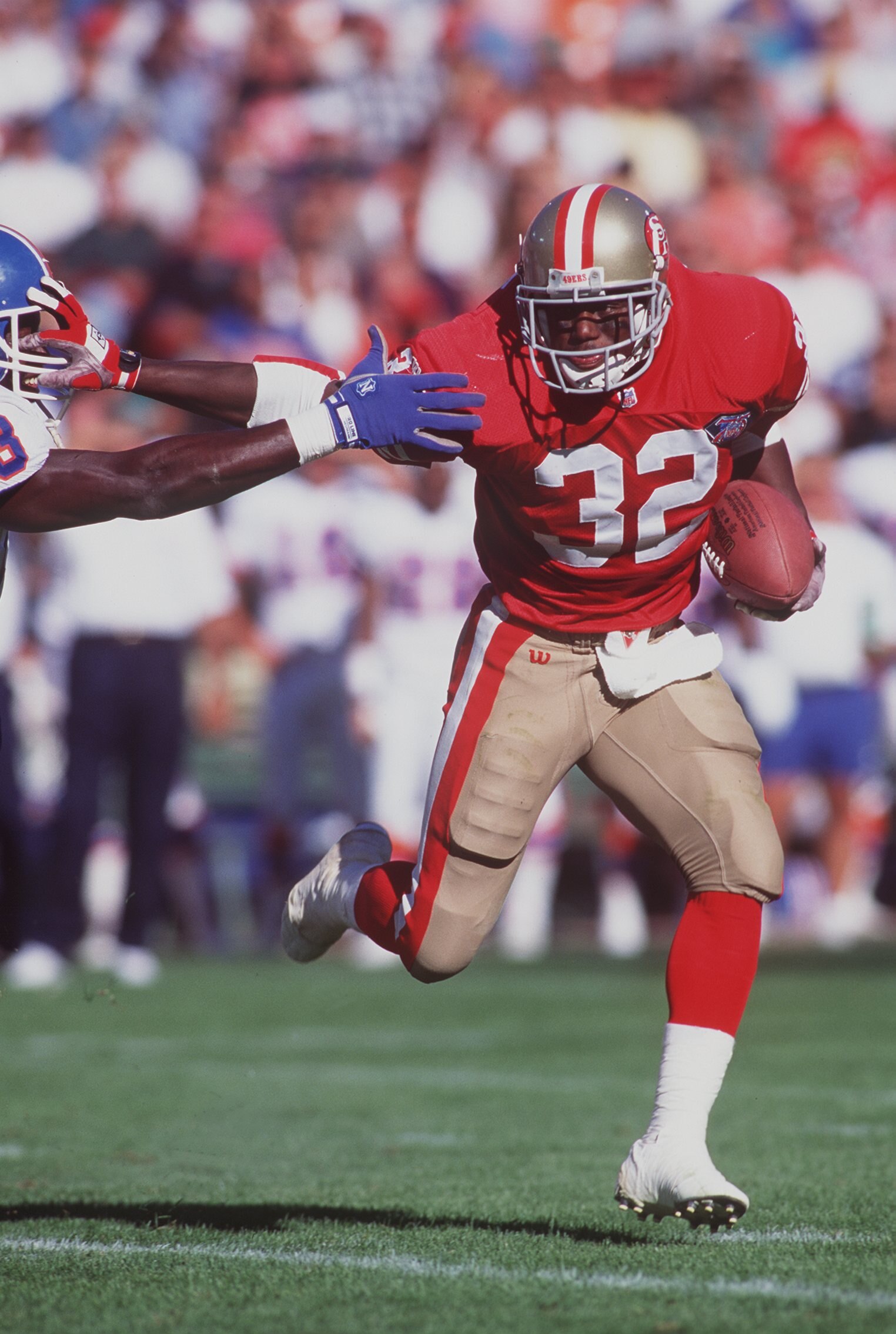 12 AUG 1994:  SAN FRANCISCO RUNNING BACK RICKEY WATTERS STIFF ARMS A DENVER DEFENDER DURING THE 49ERS 20-3 VICTORY OVER THE BRONCOS, IN A PRESEASON GAME AT CANDLESTICK PARK IN SAN FRANCISCO, CALIFORNIA.  Mandatory Credit: Otto Greule/ALLSPORT