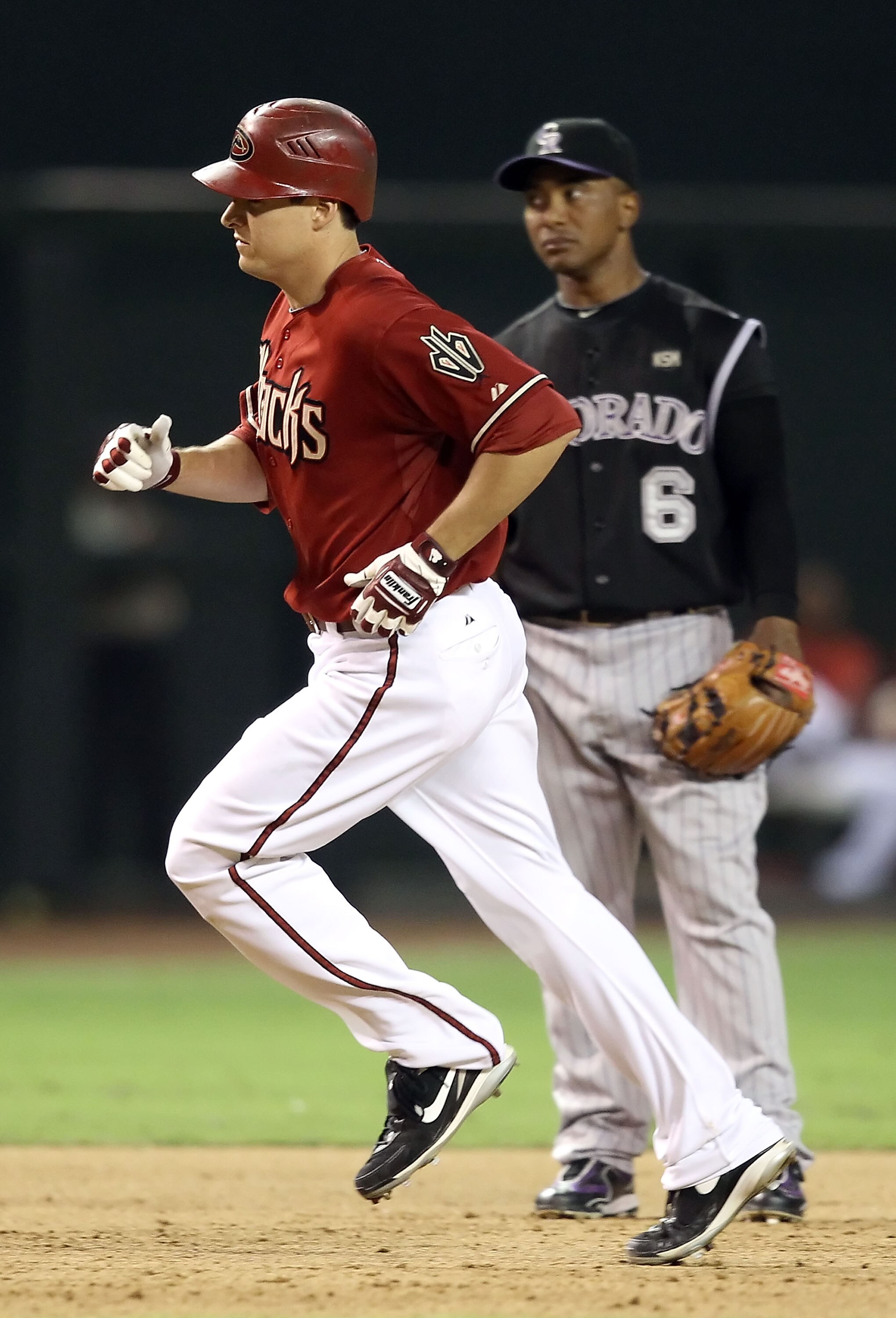 PHOENIX - SEPTEMBER 22:  Kelly Johnson #2 of the Arizona Diamondbacks rounds the bases past infielder Melvin Mora #6 of the Colorado Rockies after hitting a 2 run home run during the eighth inning of the Major League Baseball game at Chase Field on Septem