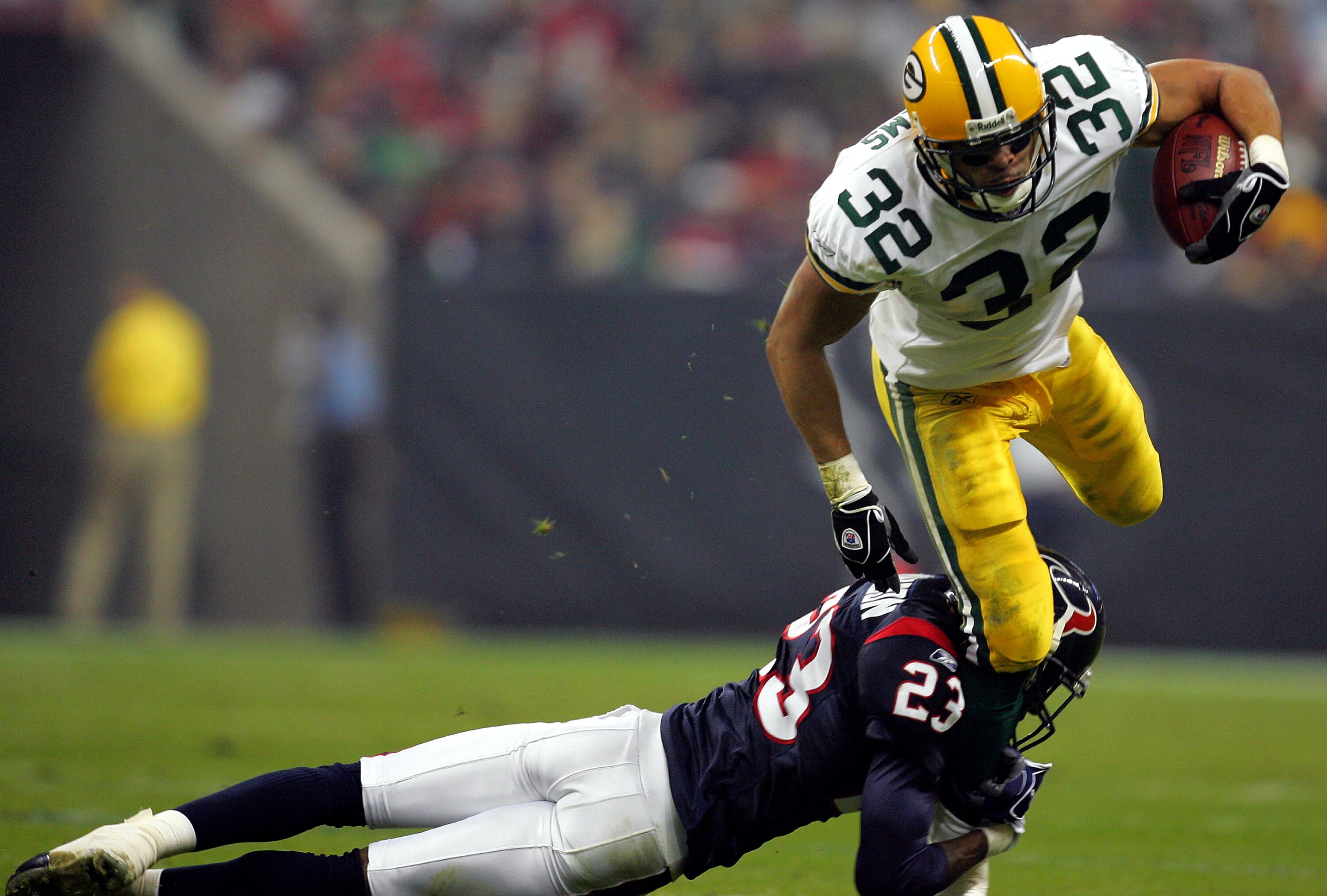 HOUSTON - NOVEMBER 21: Running back Walter Williams #32 of the Green Bay Packers is tackled by Dunta Robinson #23 of the Houston Texans on November 21, 2004 at Reliant Stadium in Houston, Texas.   (Photo by Ronald Martinez/Getty Images)