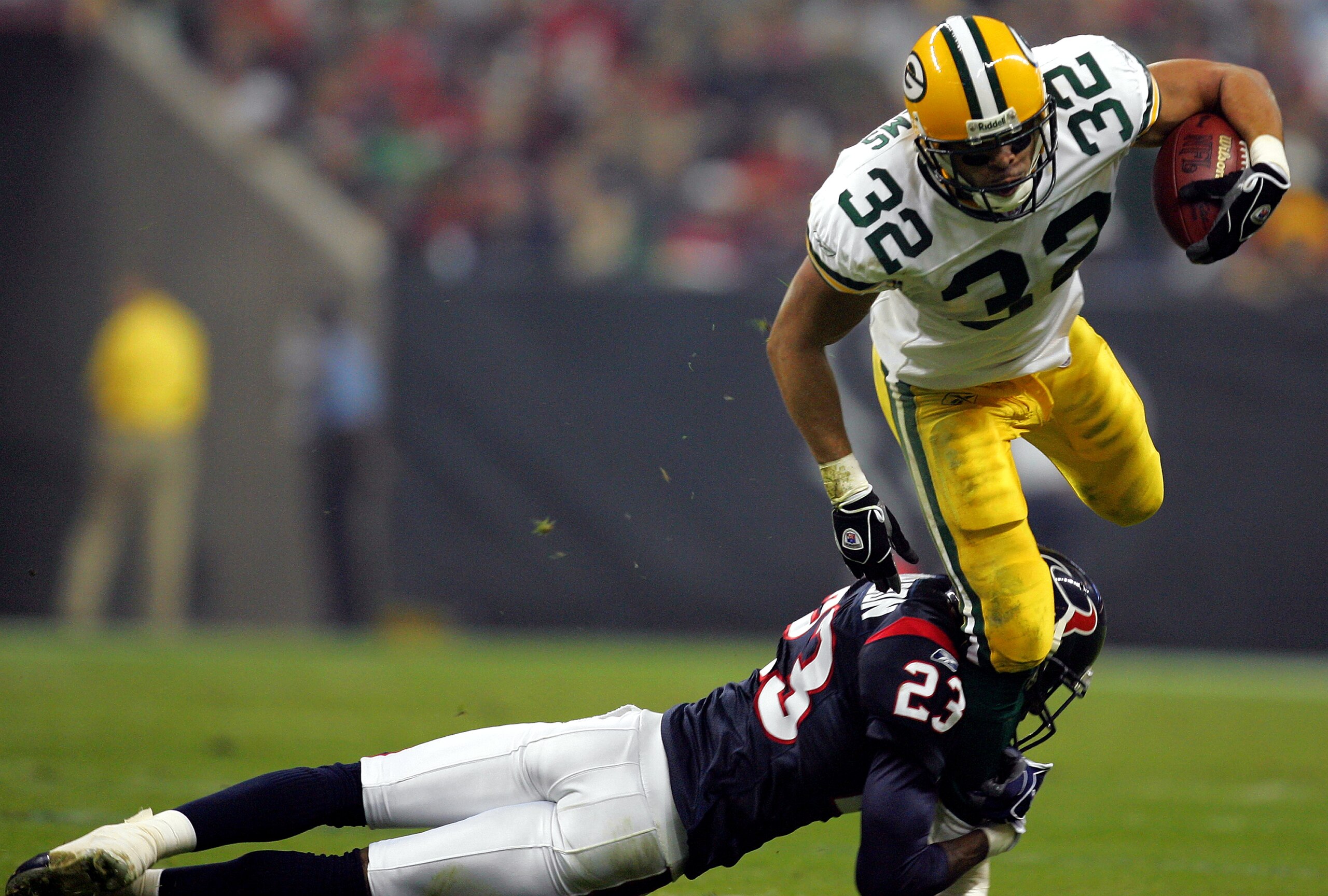 HOUSTON - NOVEMBER 21: Running back Walter Williams #32 of the Green Bay Packers is tackled by Dunta Robinson #23 of the Houston Texans on November 21, 2004 at Reliant Stadium in Houston, Texas.   (Photo by Ronald Martinez/Getty Images)