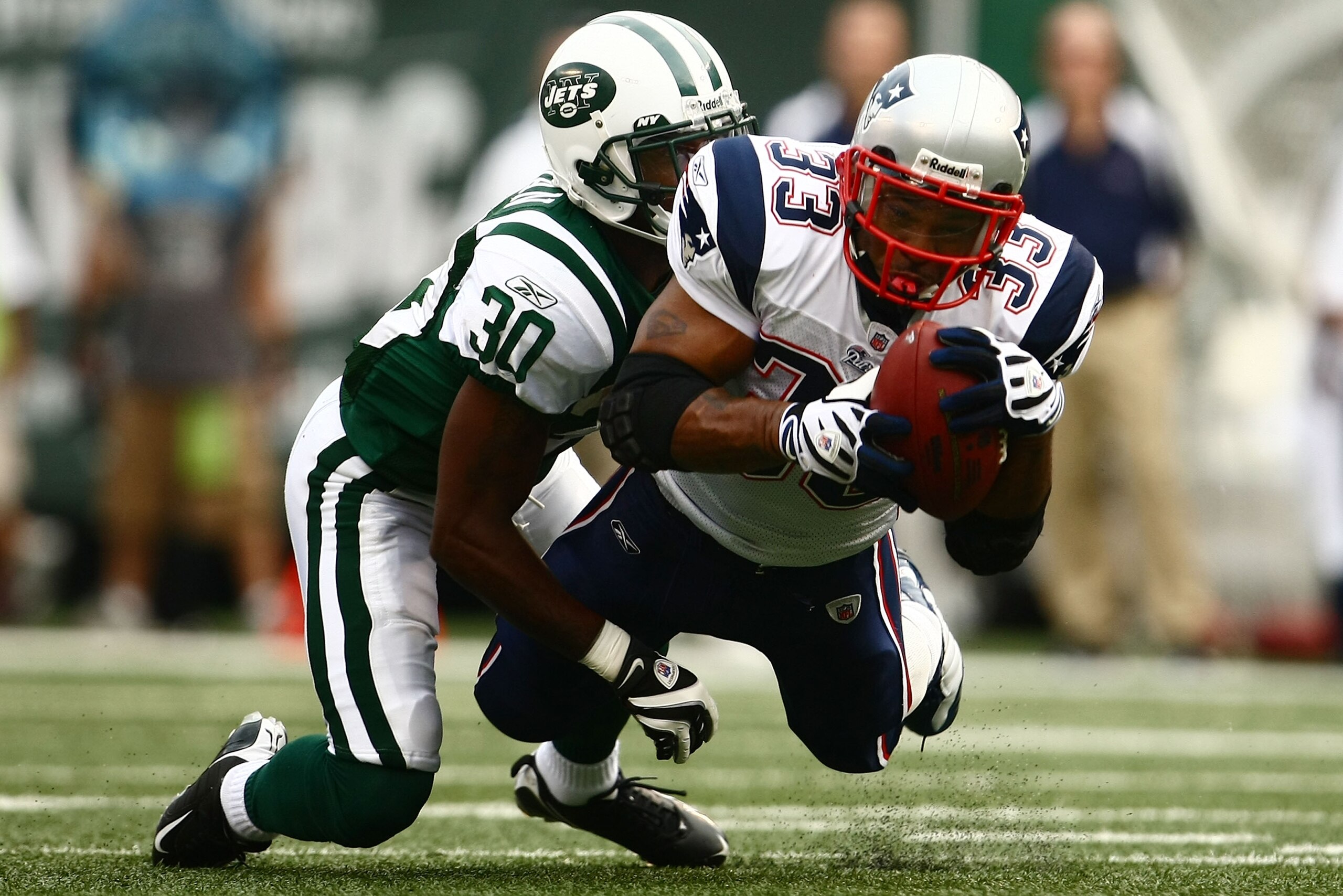 EAST RUTHERFORD, NJ - SEPTEMBER 14: Kevin Faulk of the New England Patriots makes a catch under pressure from Drew Coleman #30 of the New York Jets on September 14, 2008 at Giants Stadium in East Rutherford, New Jersey.  (Photo by Chris McGrath/Getty Imag