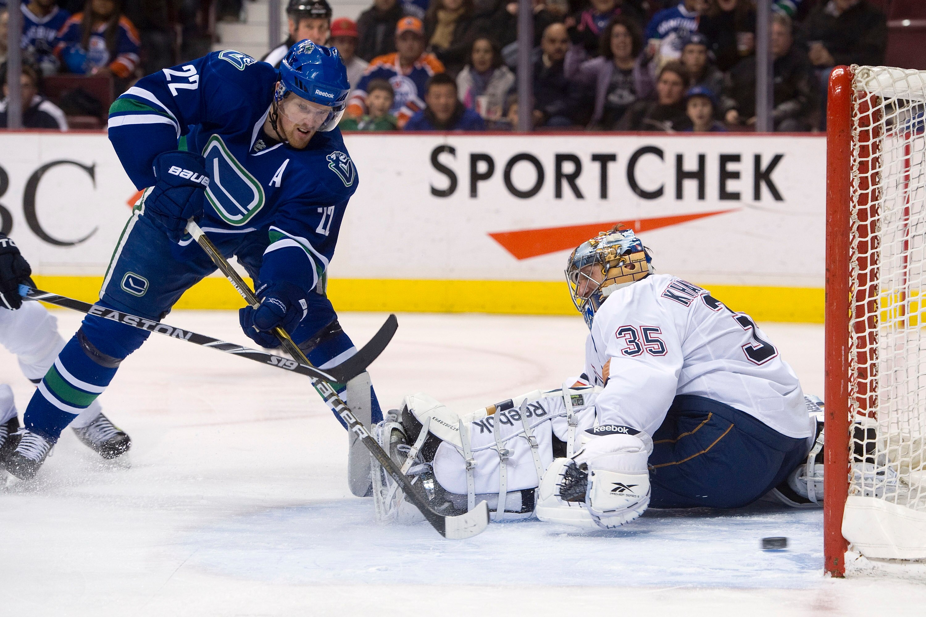 VANCOUVER, CANADA - JANUARY 7: Daniel Sedin #22 of the Vancouver Canucks slides a backhand shot past goalie Nikolai Khabibulin #35 of the Edmonton Oilers for his second goal of the night during the second period at Rogers Arena January 7, 2011 in Vancouve VANCOUVER, CANADA - JANUARY 7: Daniel Sedin #22 of the Vancouver Canucks slides a backhand shot past goalie Nikolai Khabibulin #35 of the Edmonton Oilers for his second goal of the night during the second period at Rogers Arena January 7, 2011 in Vancouve