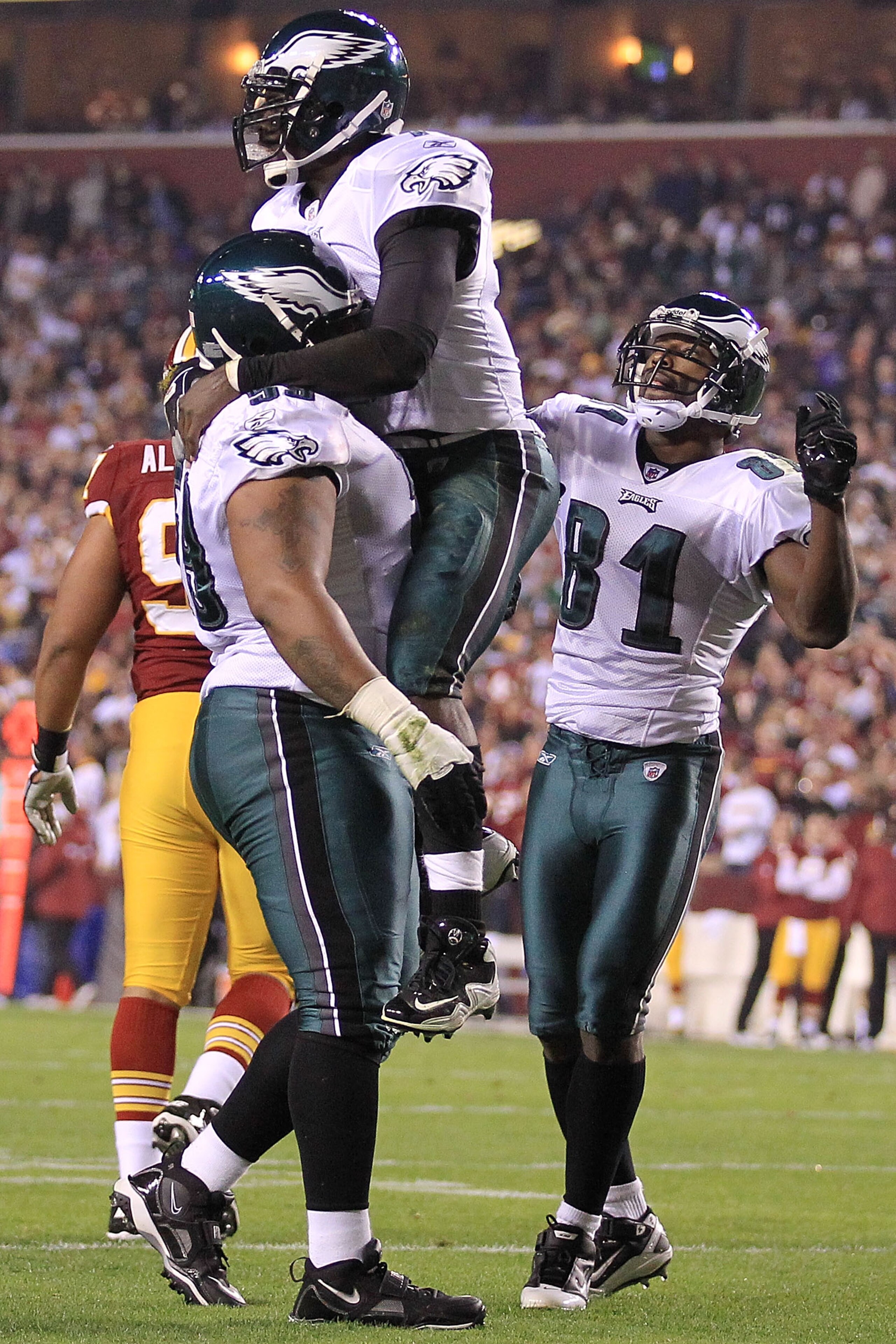 LANDOVER, MD - NOVEMBER 15:  Michael Vick #7 of the Philadelphia Eagles is congratulated by team mate Nick Cole #59 and Jason Avant #81 after scoring a touchdown against the Washington Redskins on November 15, 2010 at FedExField in Landover, Maryland.  (P